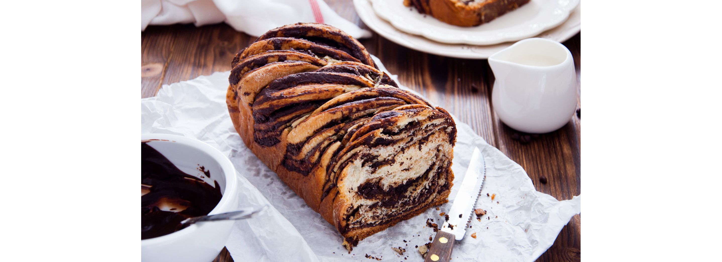 Swirled babka bread resting on white parchment paper.