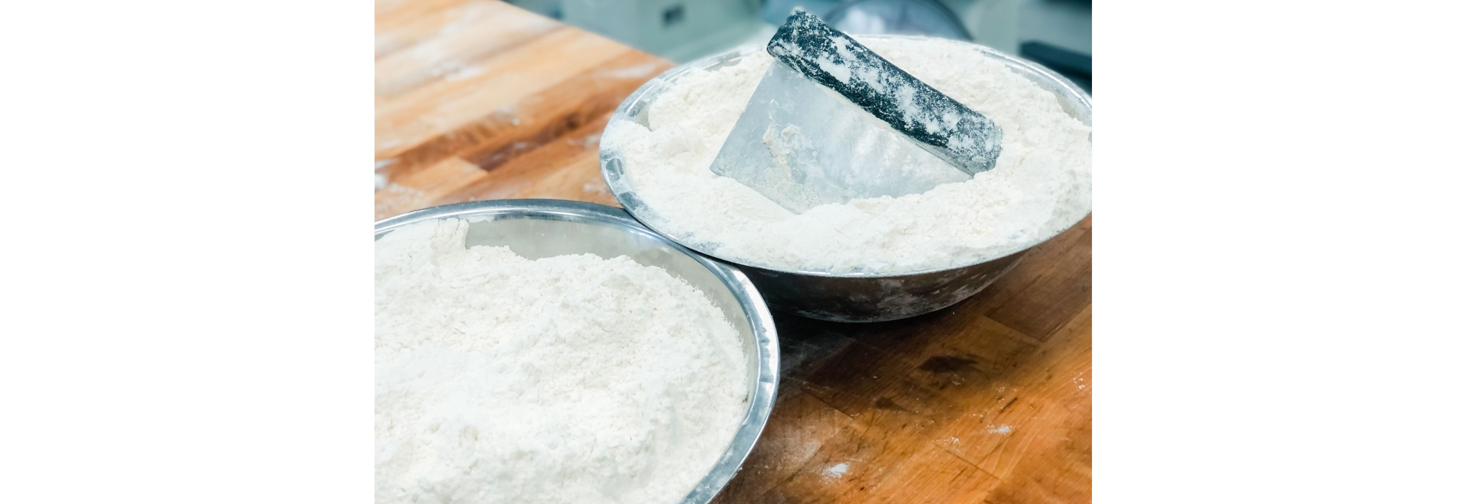 Two metal bowls filled with flour.