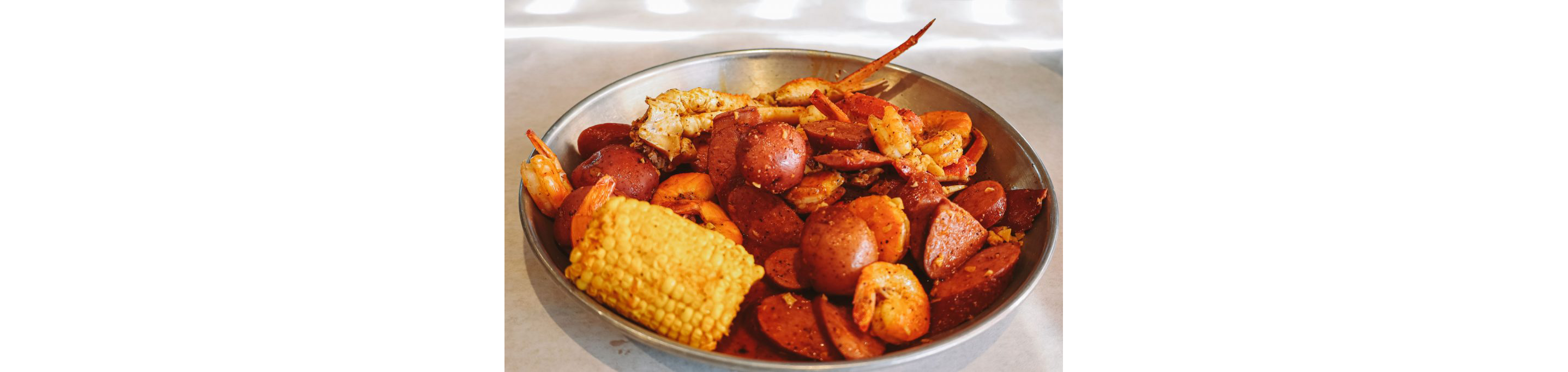 A metal bowl overflowing with a seafood boil.