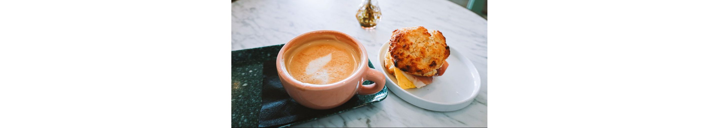 A cappuccino and a freshly made breakfast sandwich.