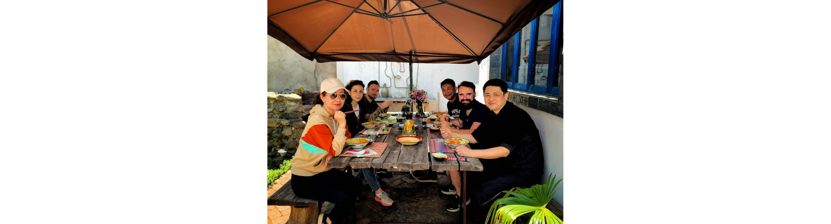 People eating outside at a large table.