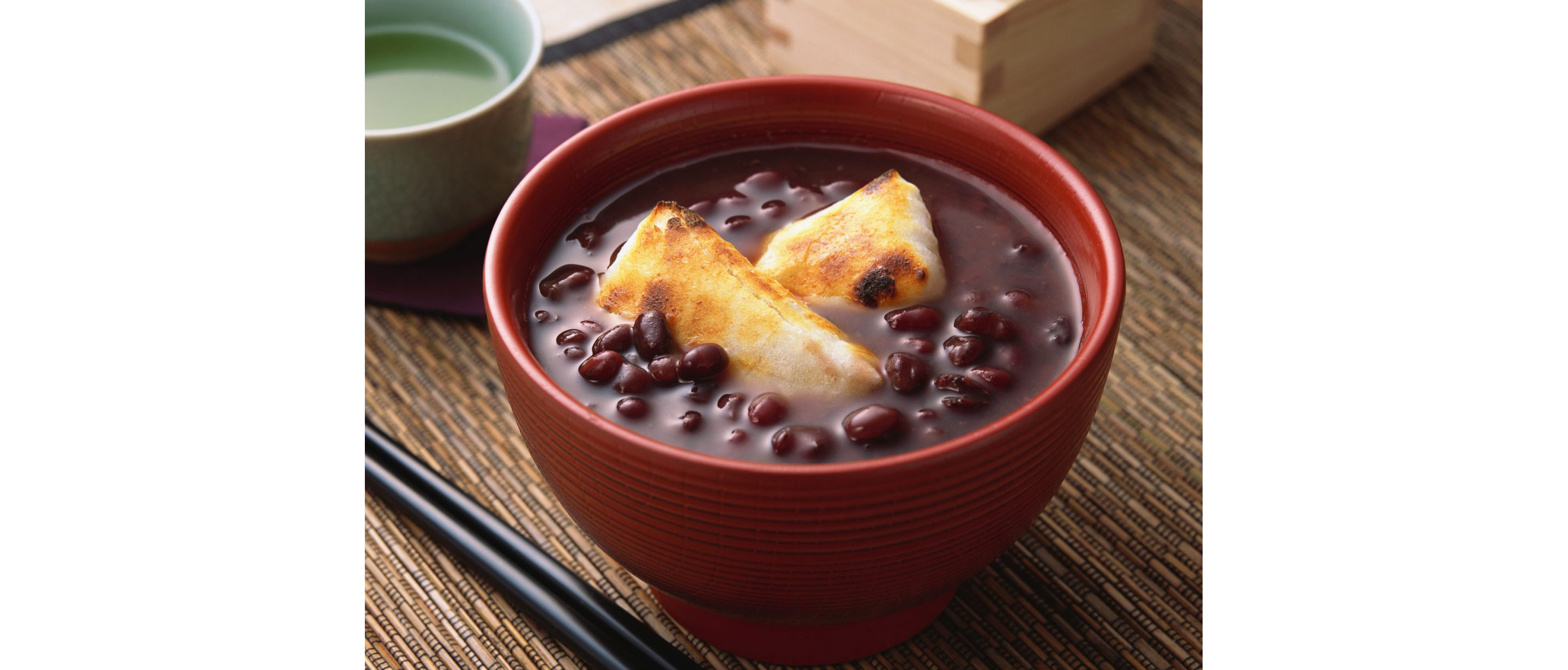 A sweet red bean soup in a dark orange bowl.