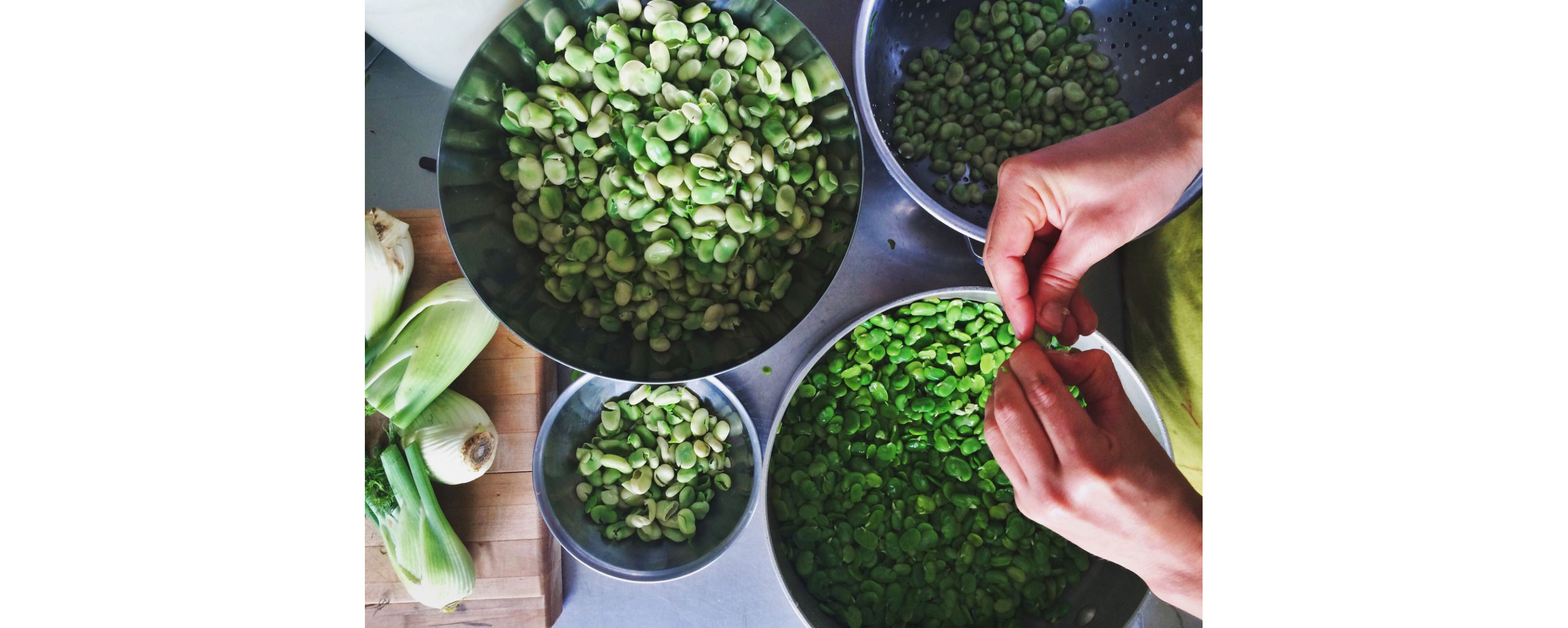 Four metal bowls of varying sizes filled with fava beans.