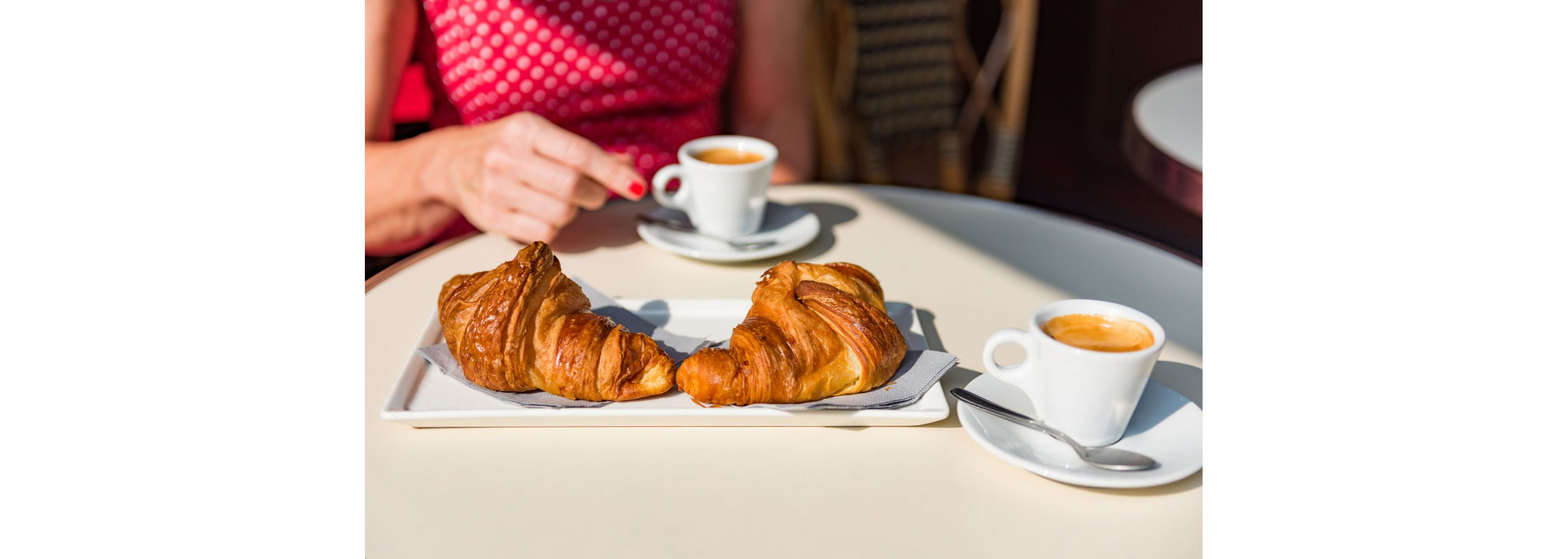 Two croissants on a delicate white dish.