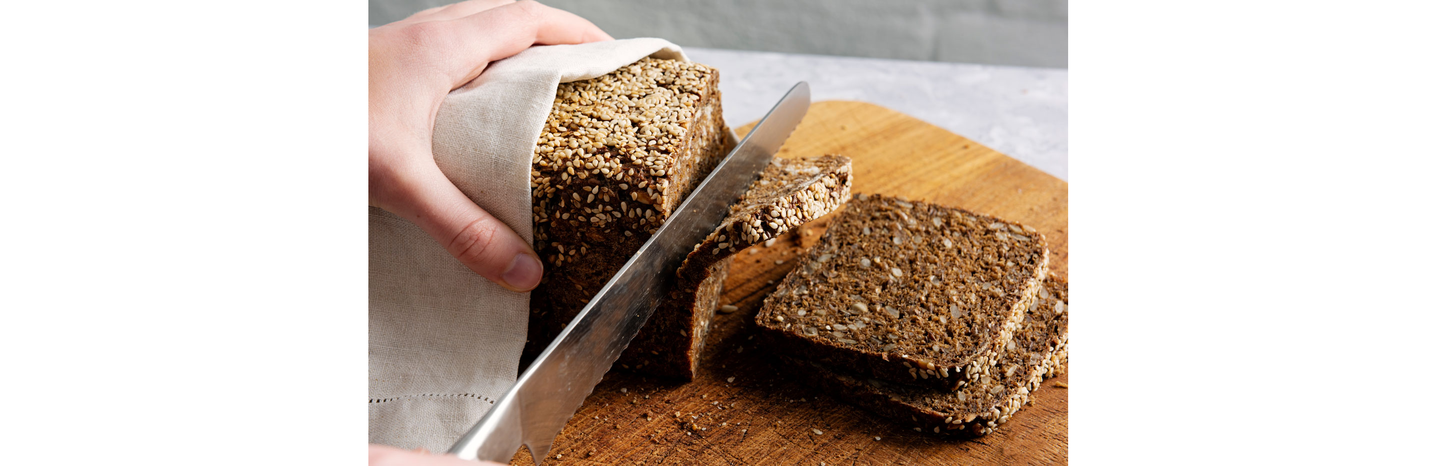 A person slicing rye bread.