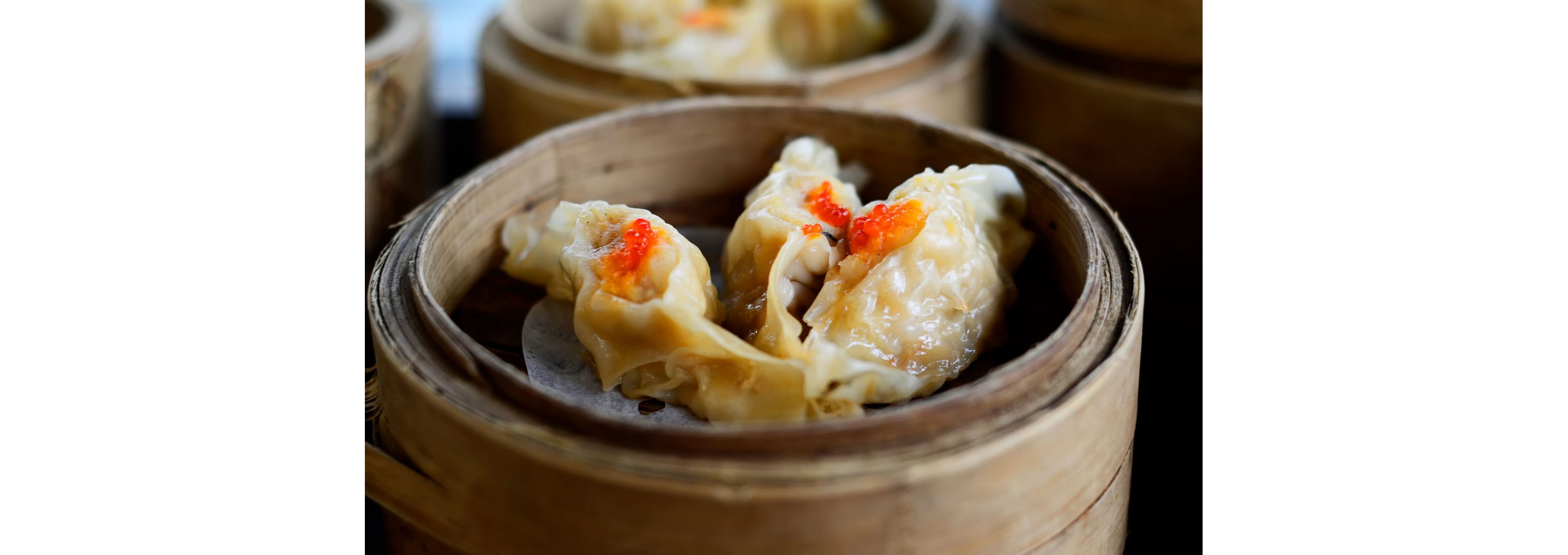 A small containter filled with three fresh dumplings.