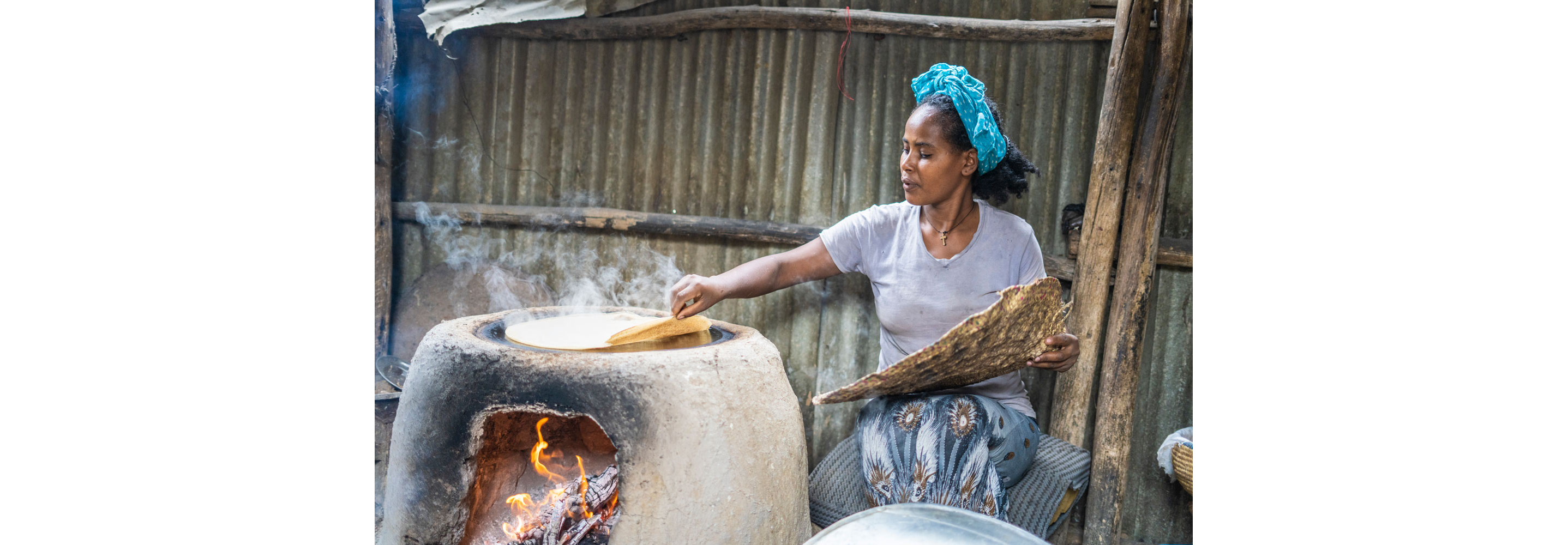 A woman slowly lifting the edges of Ethiopian flatbread.