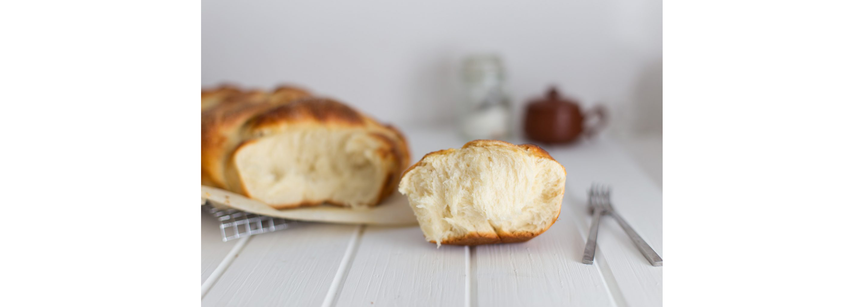 Pulled apart brioche bread on a white table.