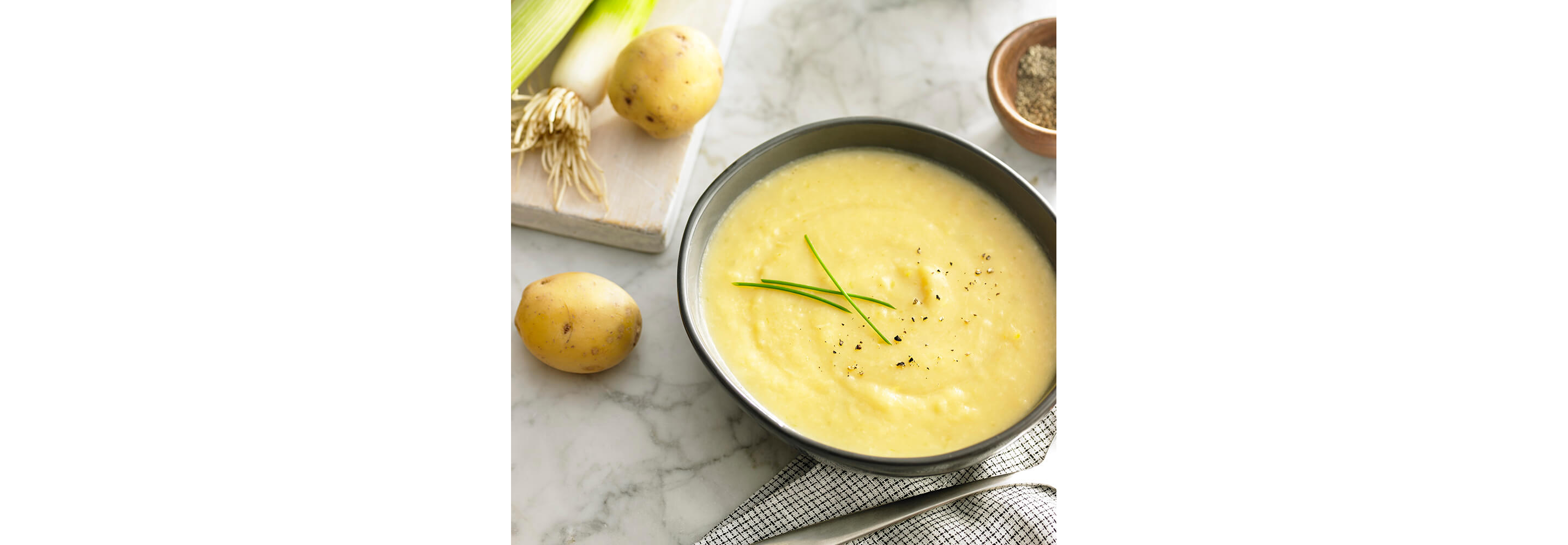 A creamy bowl of polenta garnished with fresh herbs and seasonings.