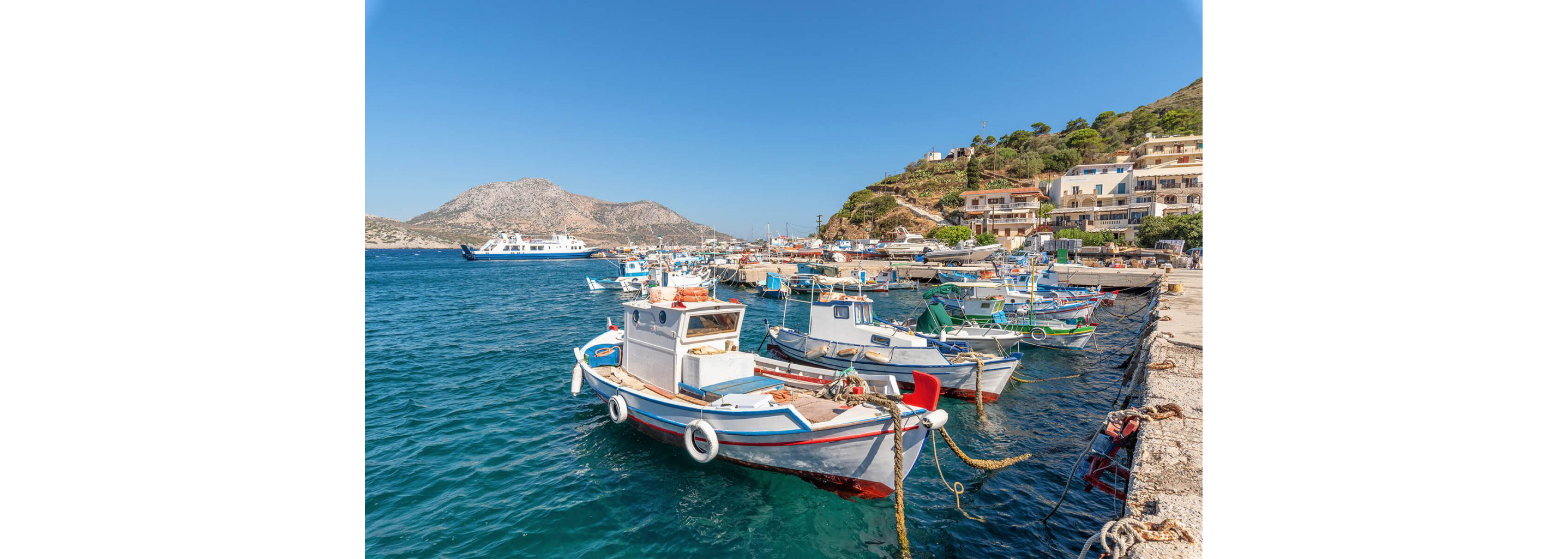 Docked, empty fishing boats floating on brilliantly blue water