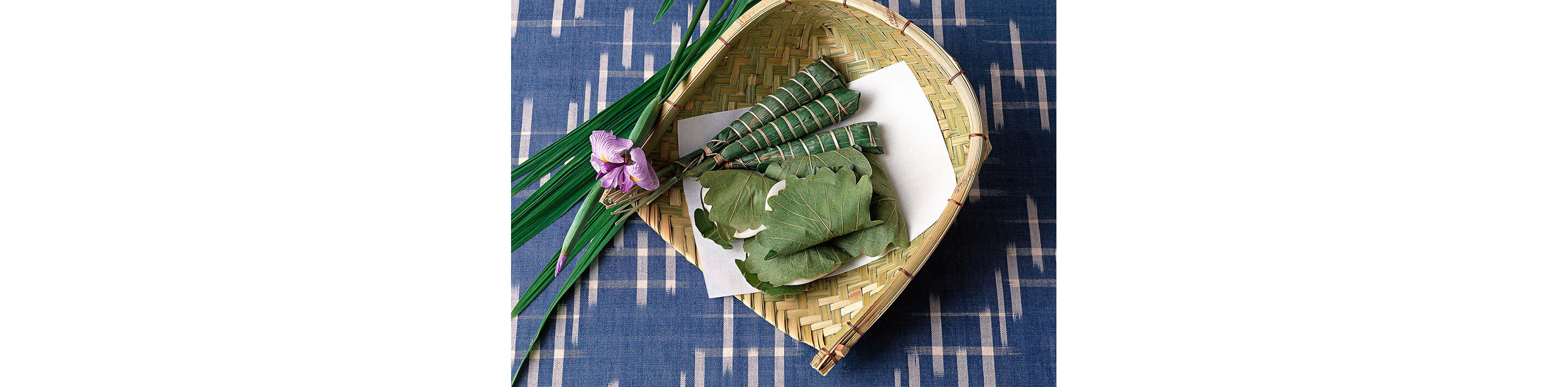 Bundles of bamboo leaves resting in a woven basket.