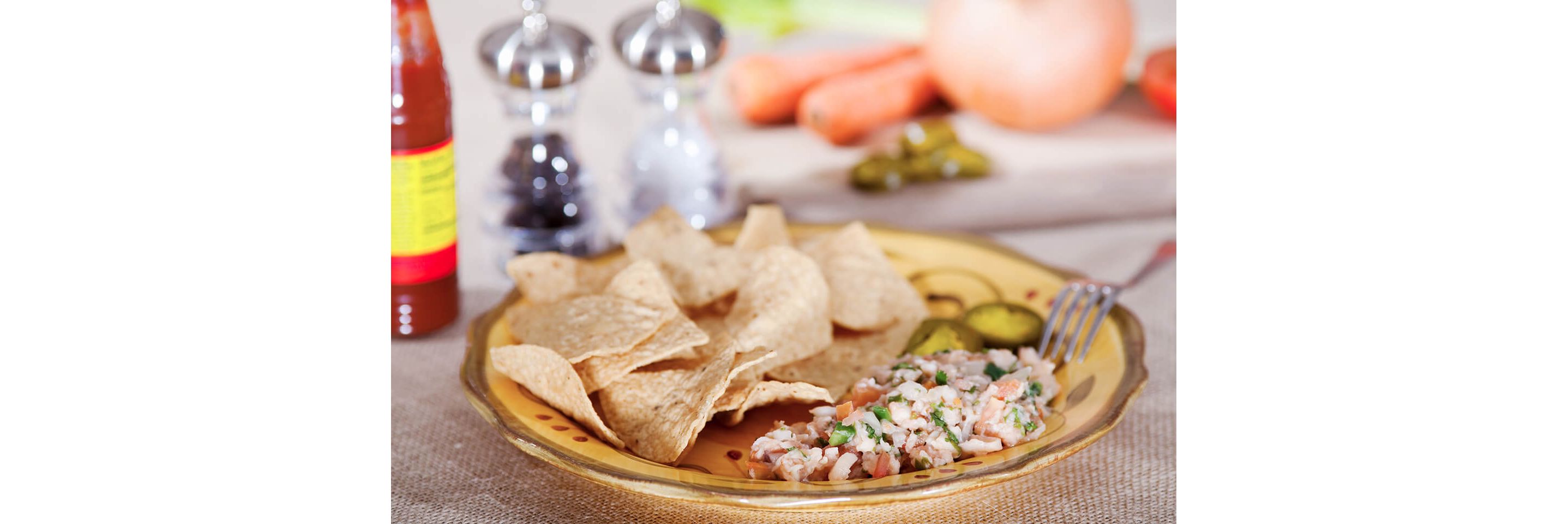 A plate filled with crisp tortilla chips and freshly made ceviche.