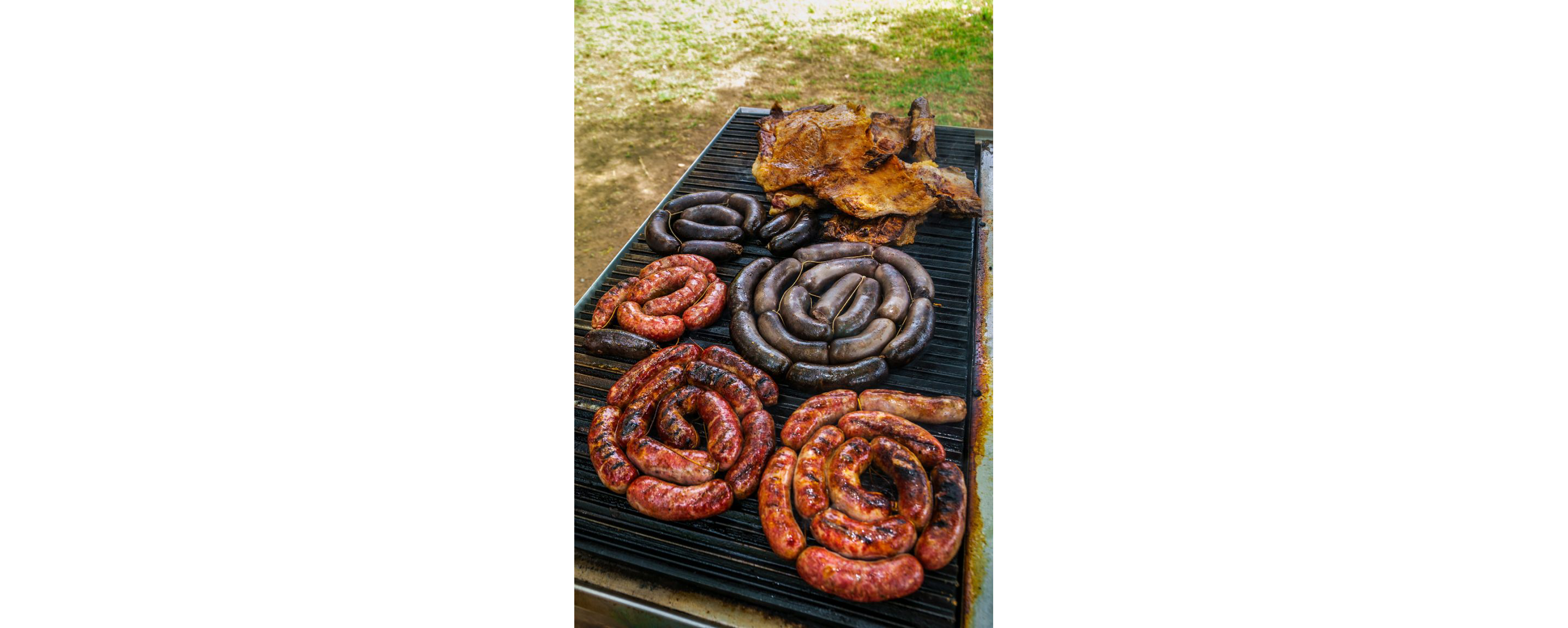 A variety of sausages and meats on a grill.