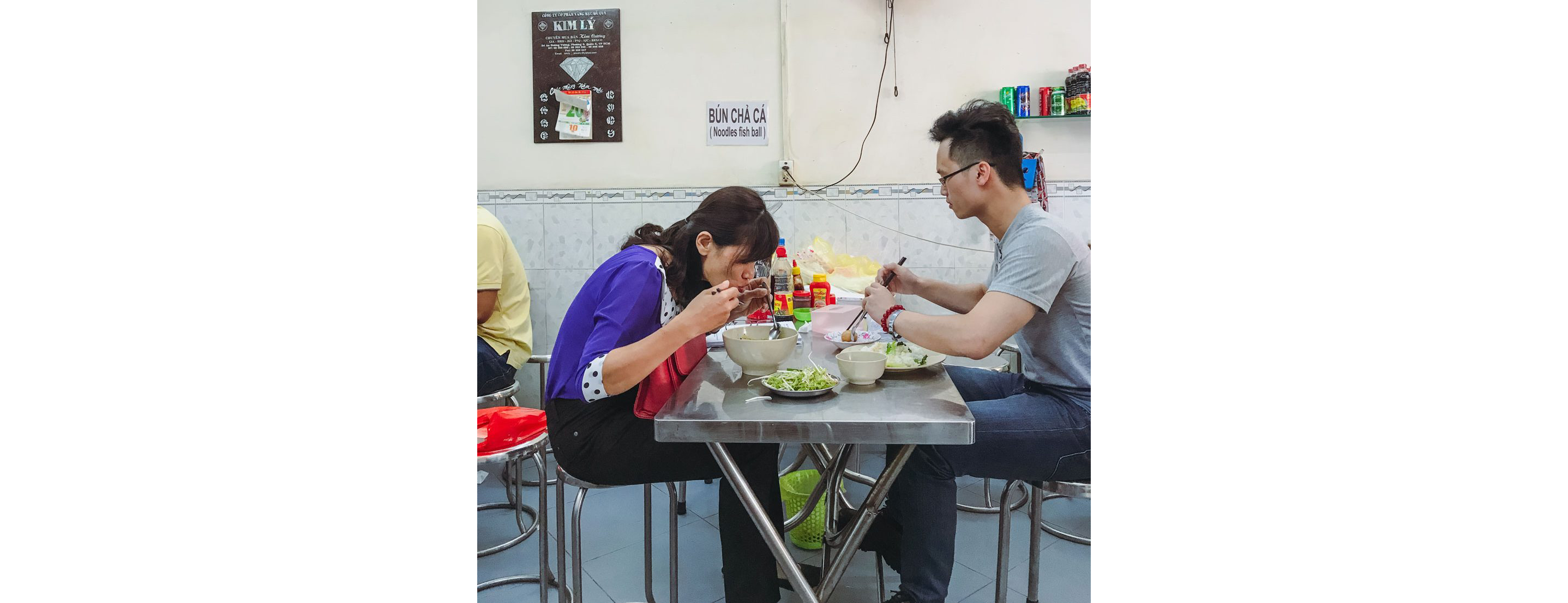 Two people enjoying their food at a small table.