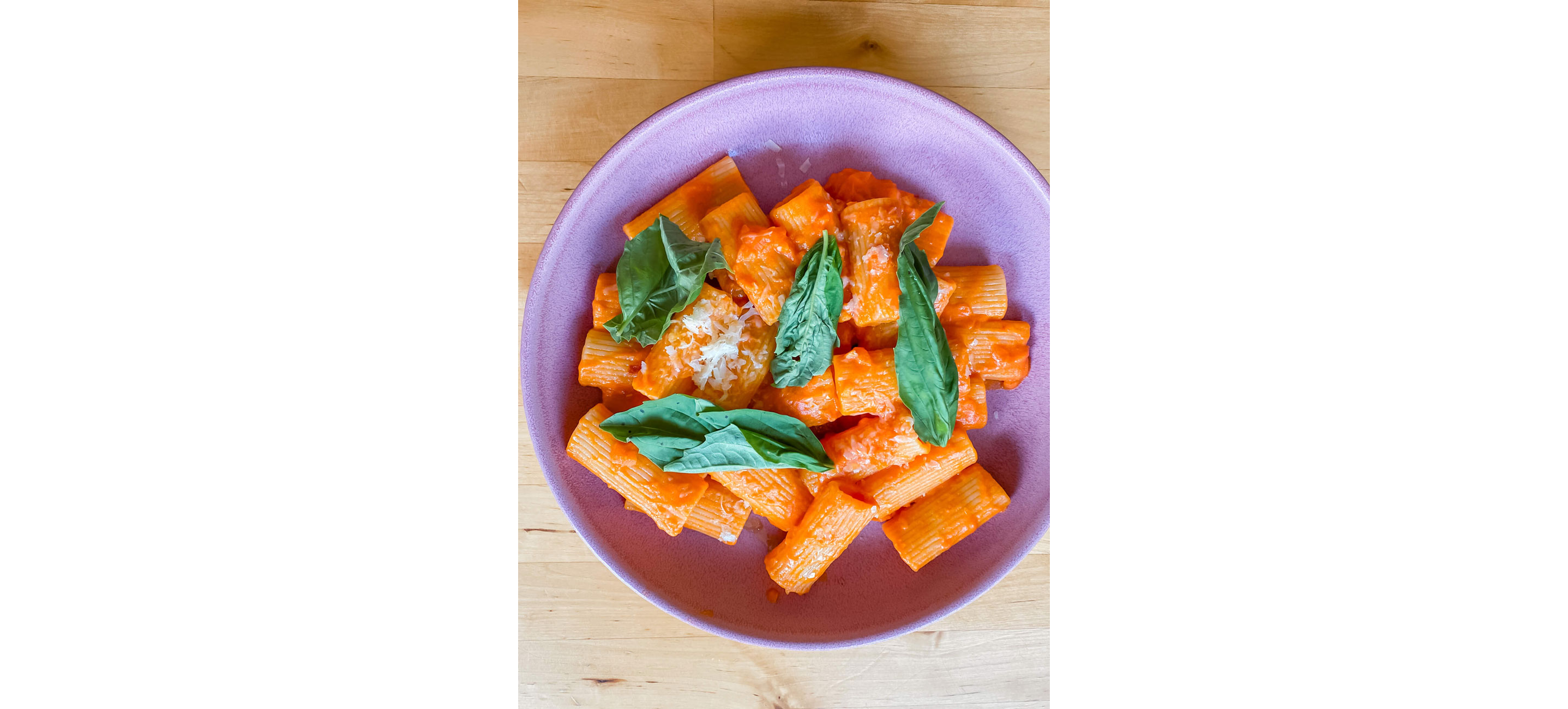 A plate of vodka sauce pasta topped with basil.