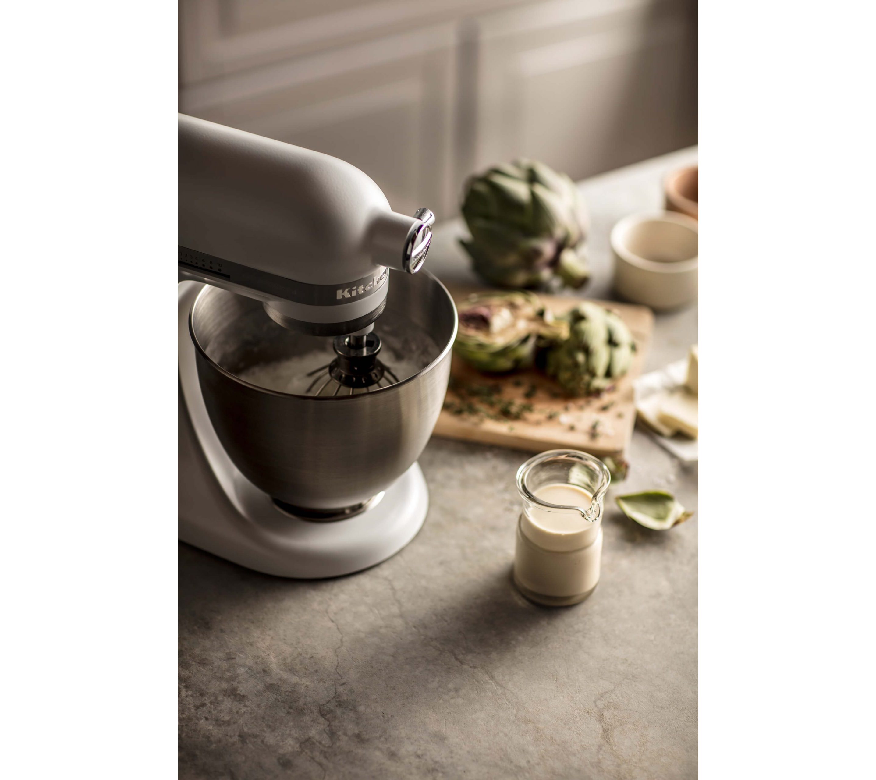 A KitchenAid® Stand Mixer mixing away on a kitchen countertop.