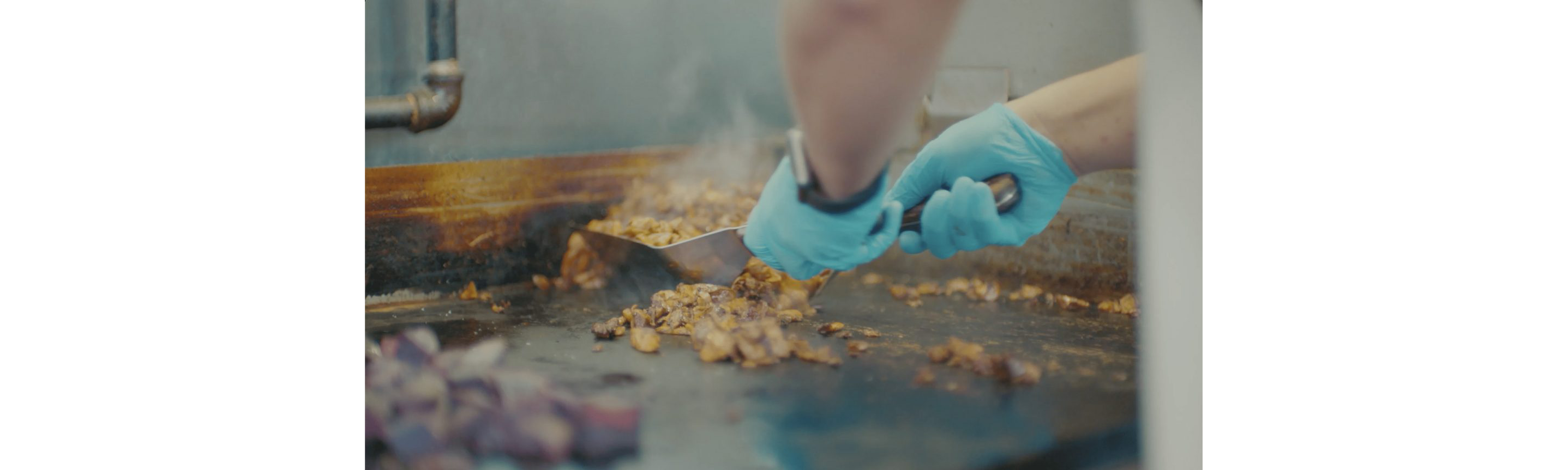 A person cooking over a flat top grill.