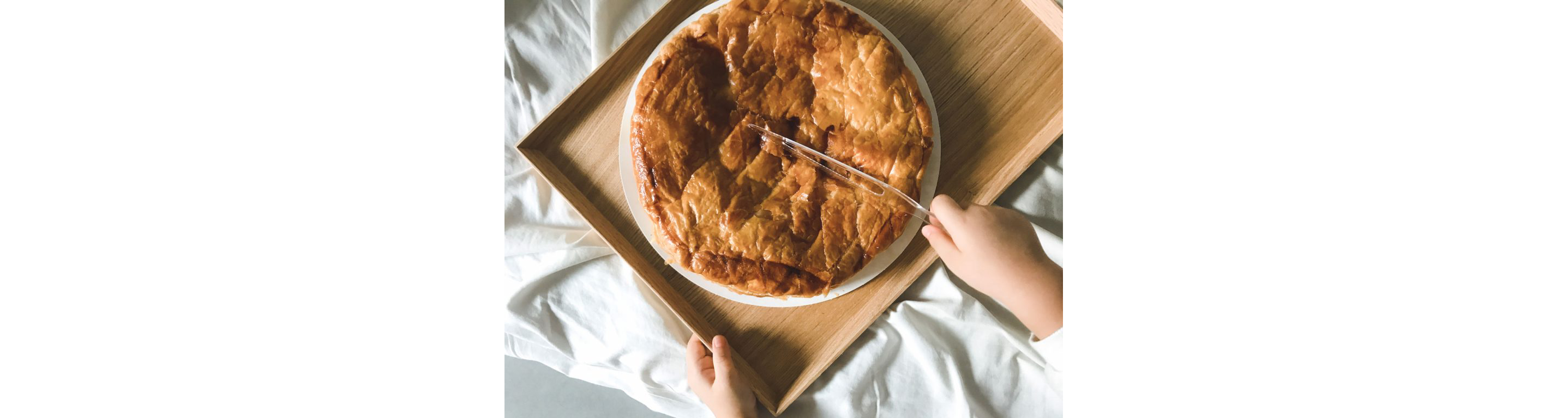 A person gently slicing the galette des rois.