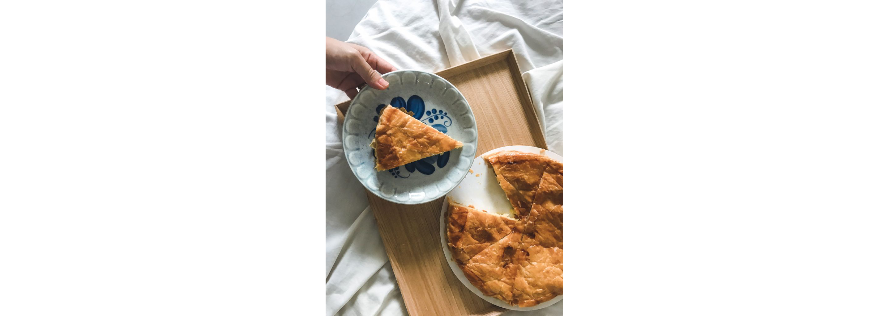 A delicate, blue plate holding a slice of galette des rois.