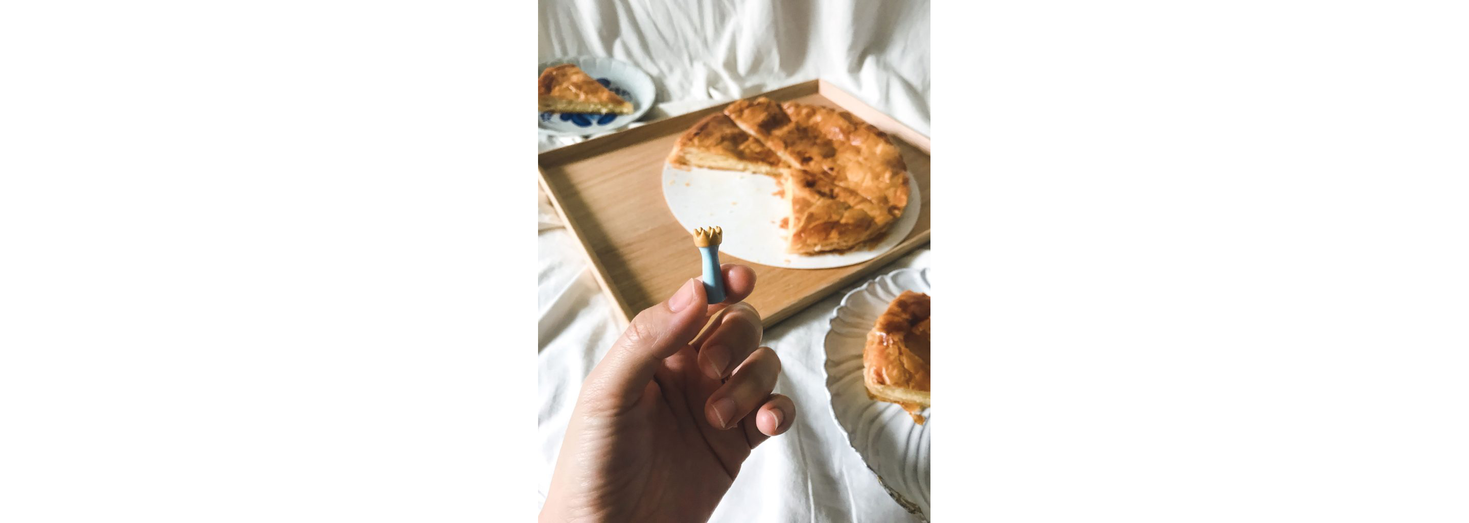 A person holding a porcelain fève from the galette des rois.