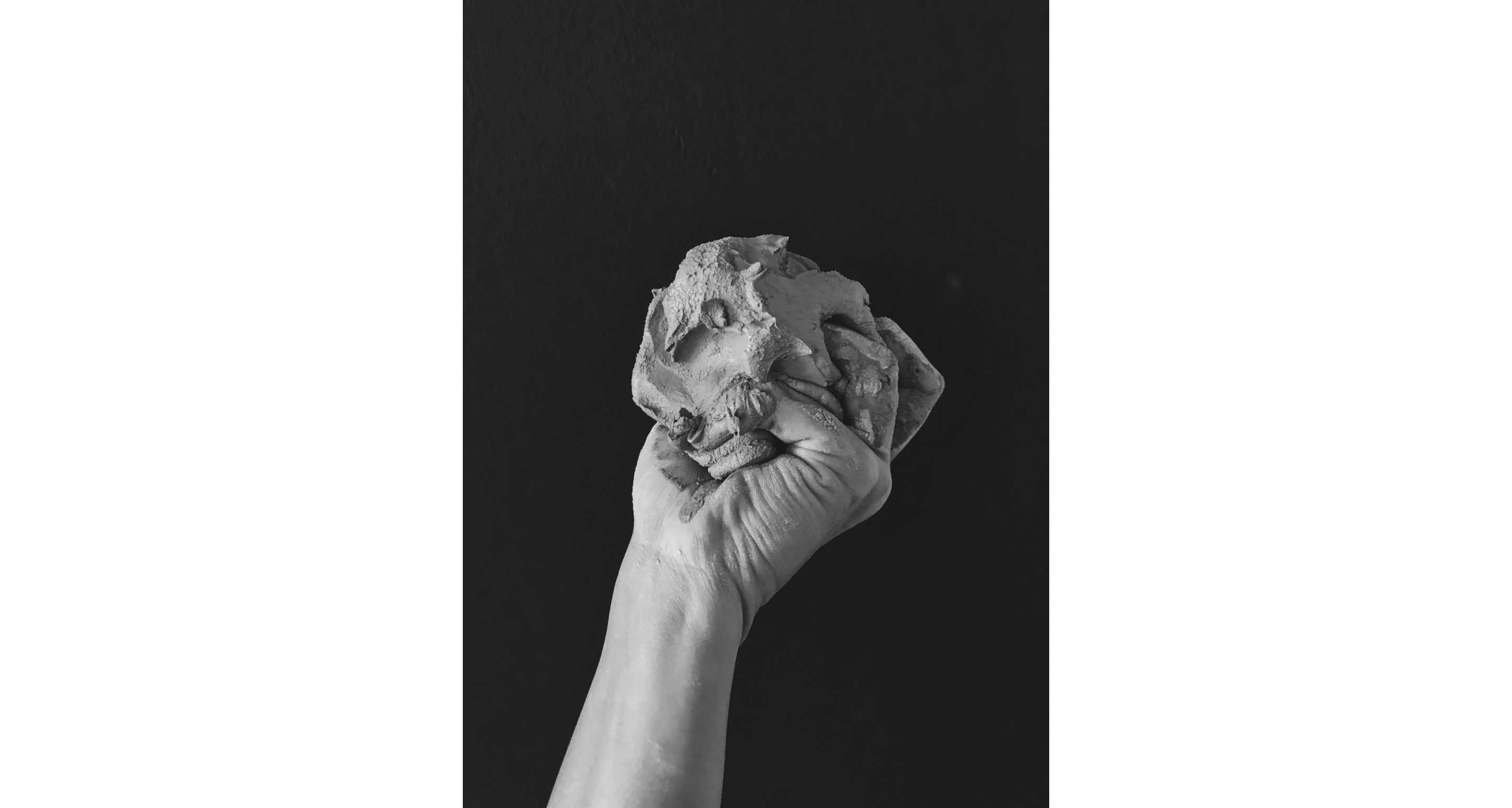 A hand holding a large wad of clay.
