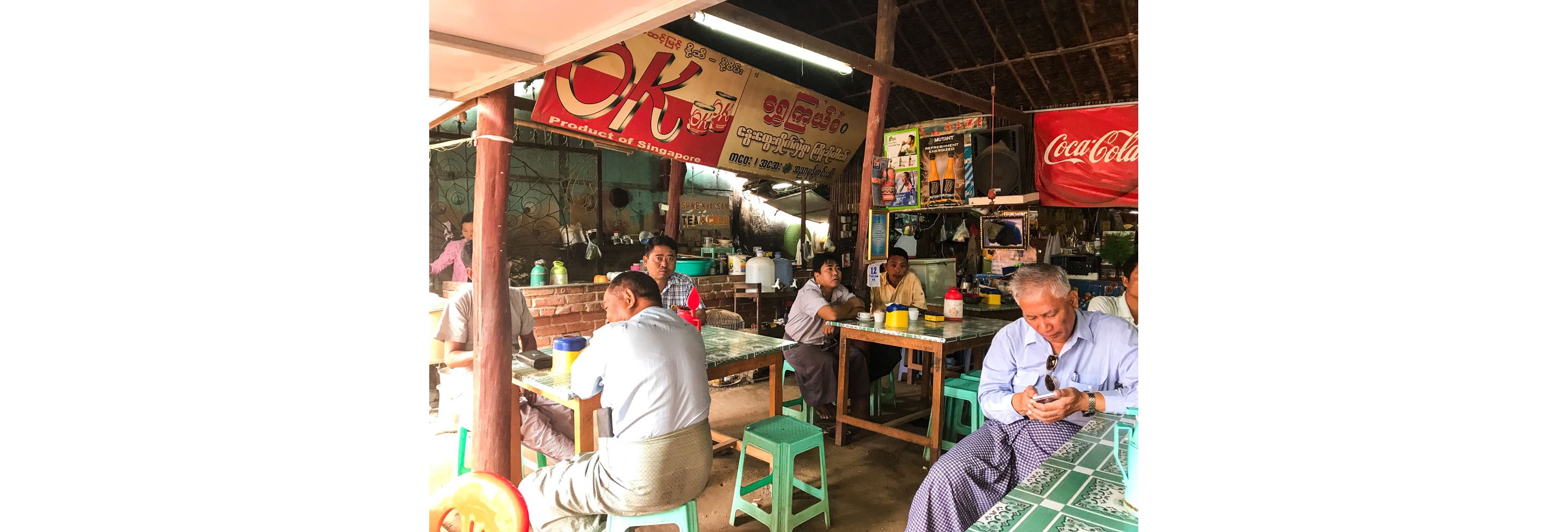  A local eatery in Myanmar filled with guests sitting on stools.