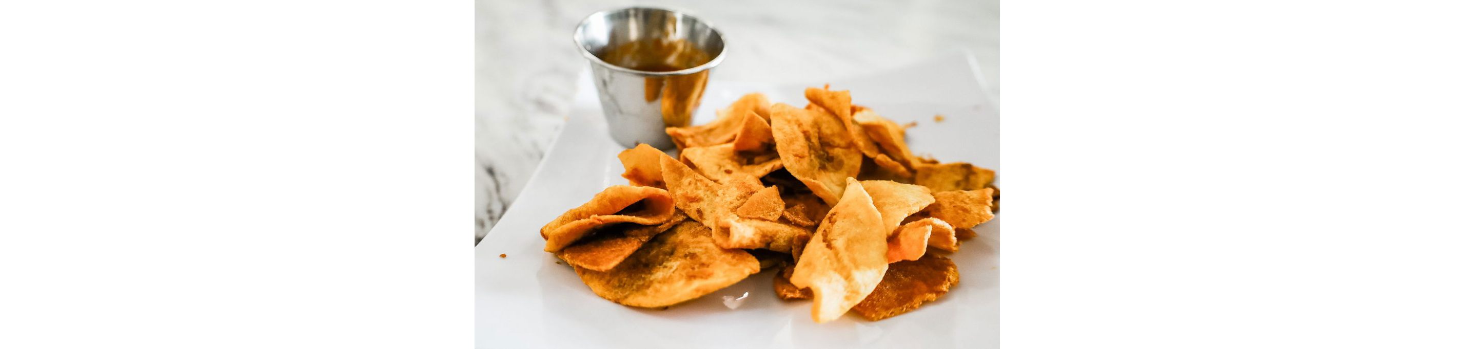 Plantain chips on a white plate.