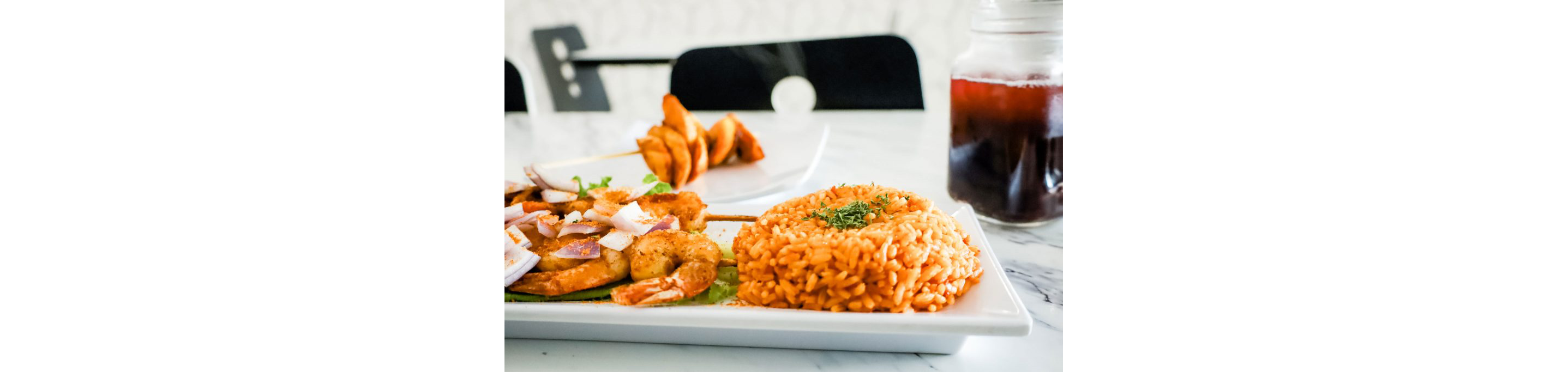 A plate of rice and grilled shrimps.