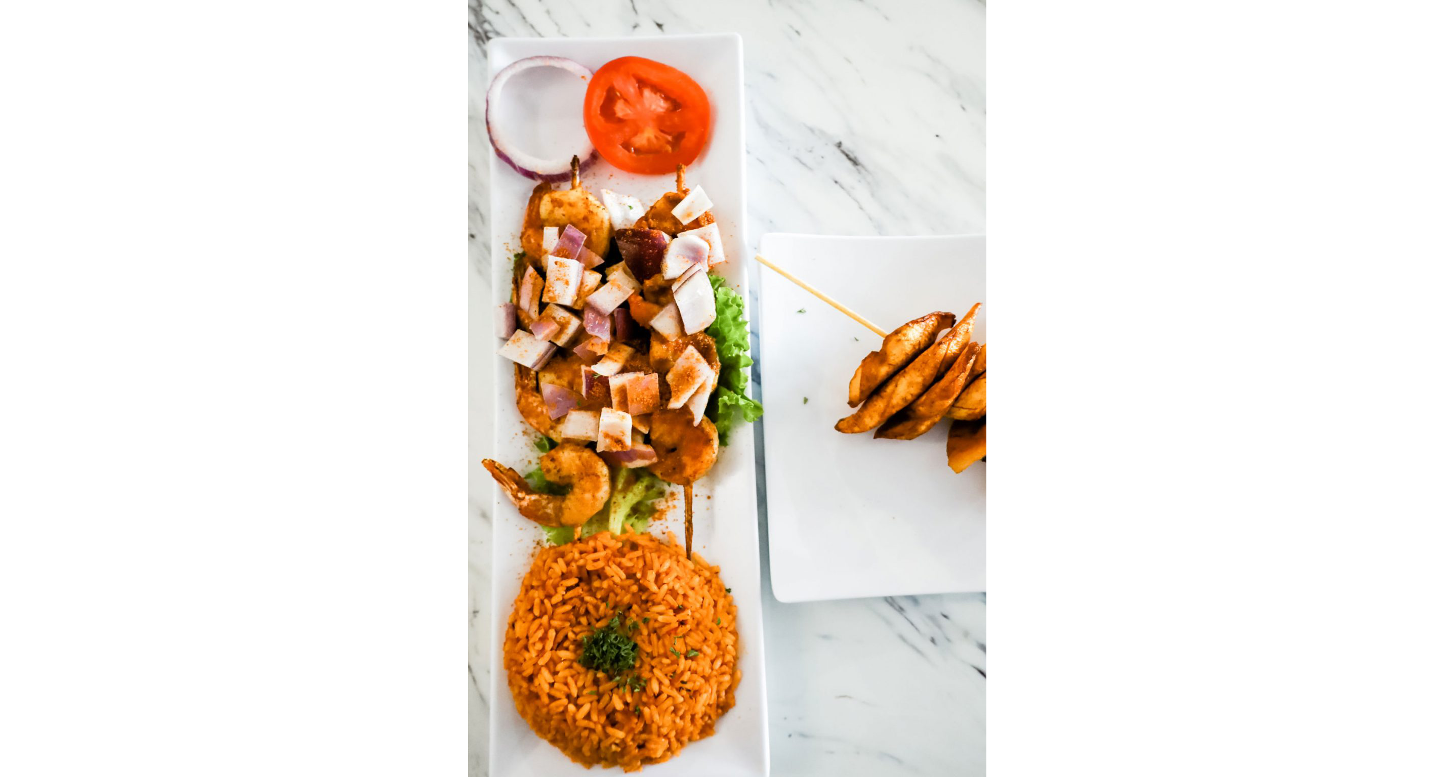A plate of grilled shrimps on two skewers.