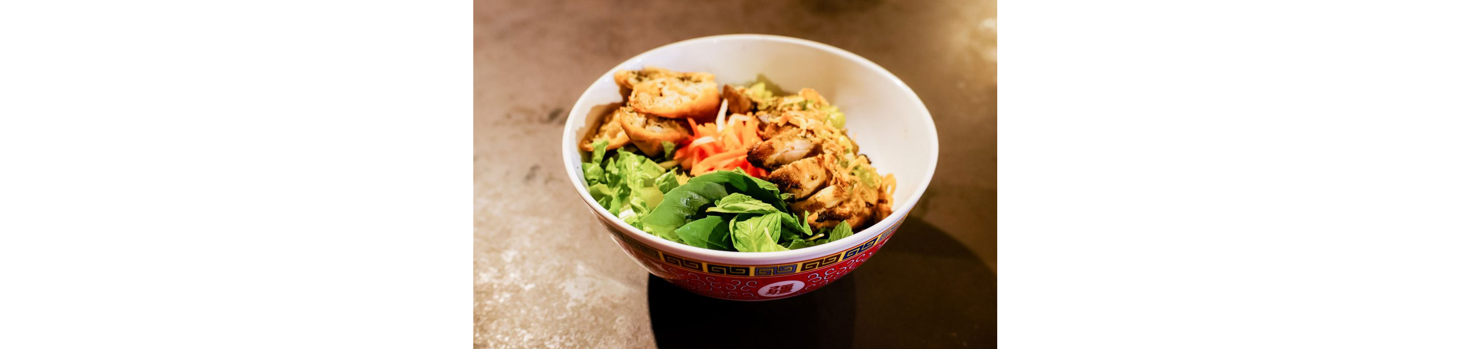 A bowl of Viatnamese noodles topped with grilled chicken.