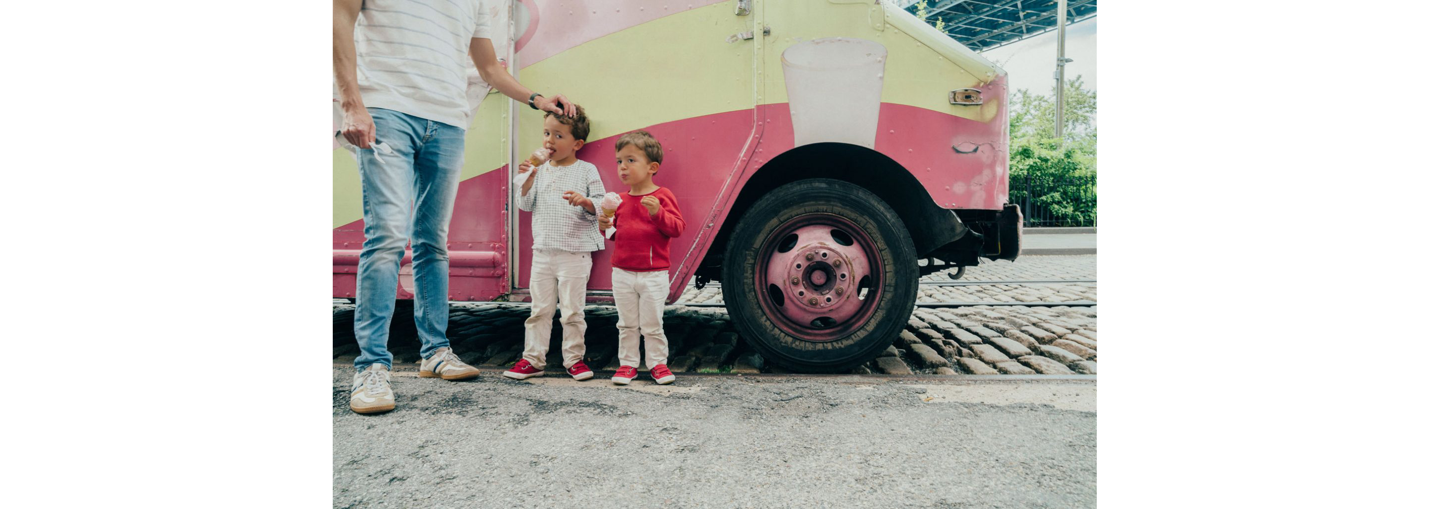 A parent and two young children enjoying their own ice cream cones.