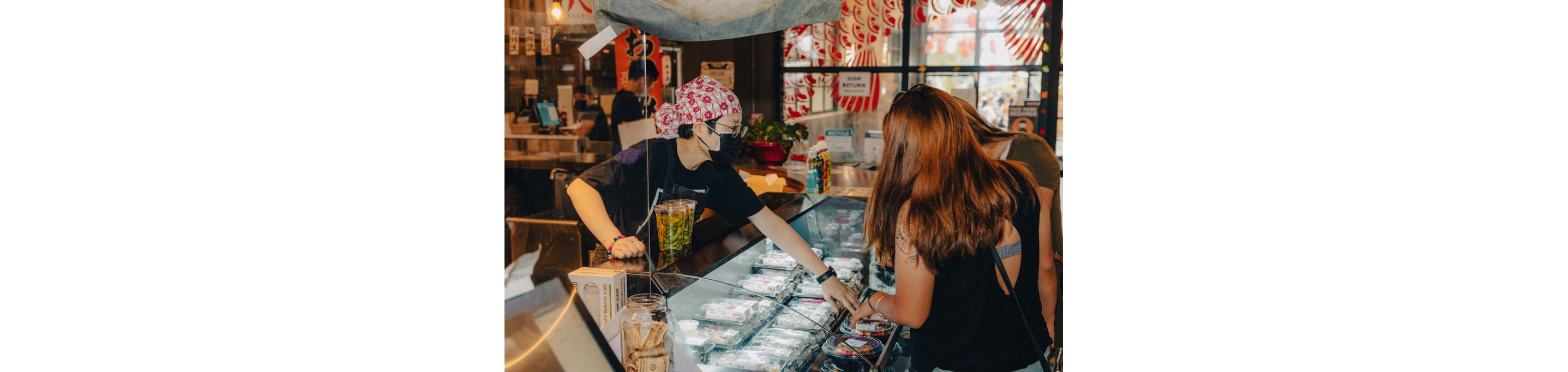 A person assisting customers over the counter.