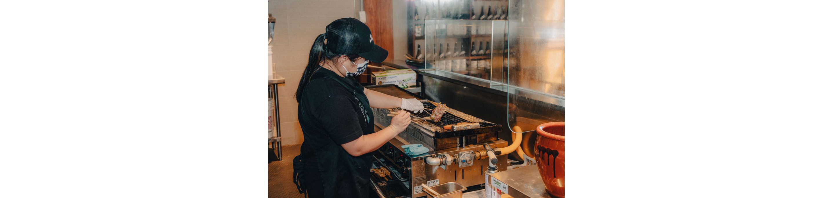 A person cooking over an indoor grill.