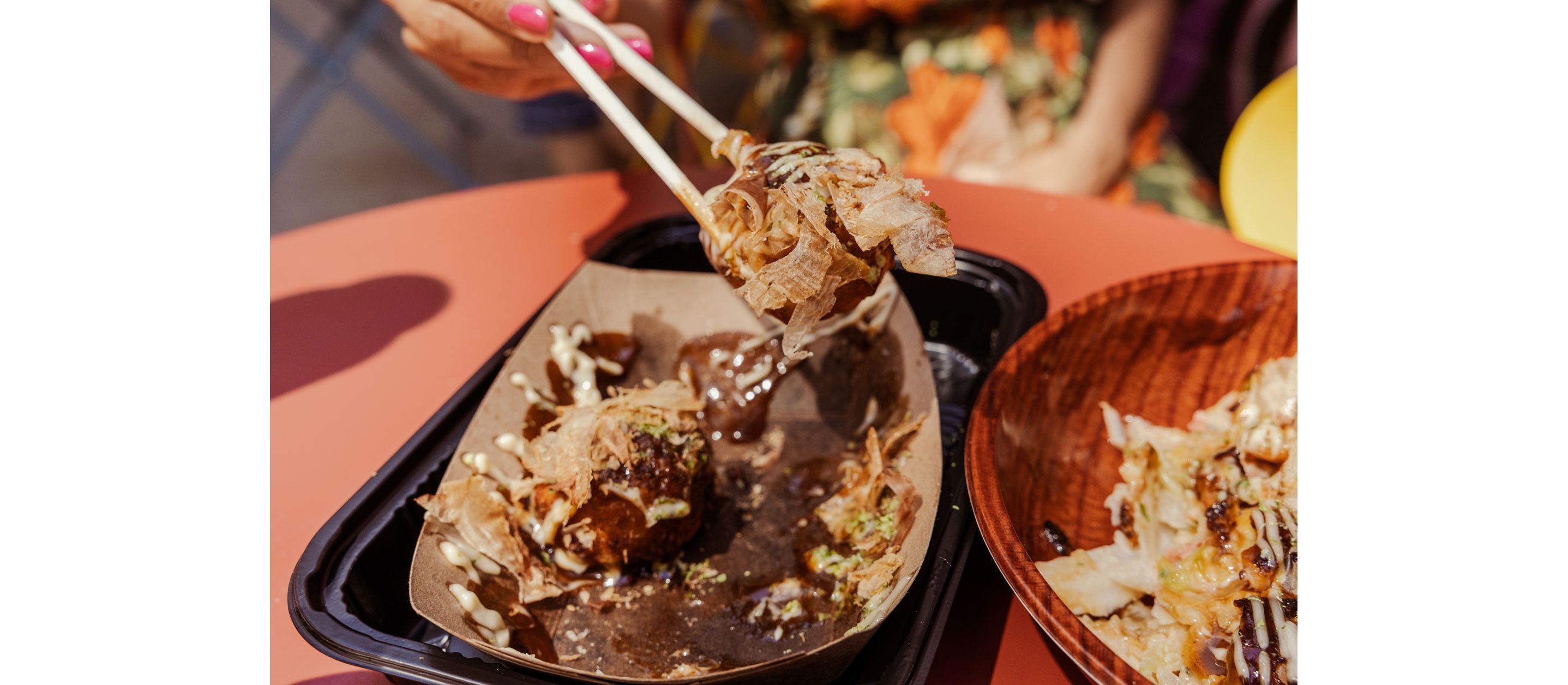 A set of chopsticks holding delicious Japanese food.