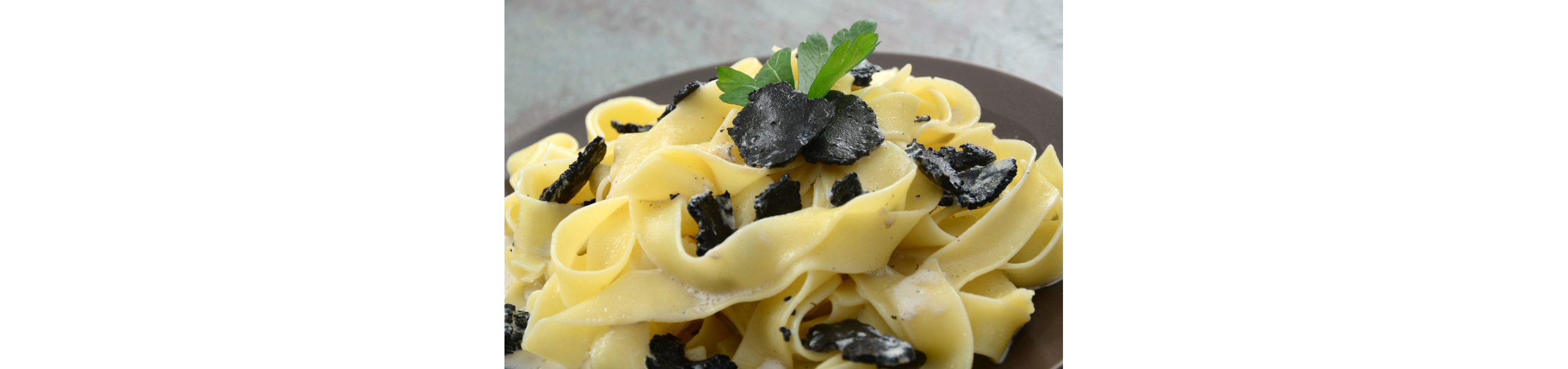 Fresh pasta topped with sliced black truffle mushrooms.