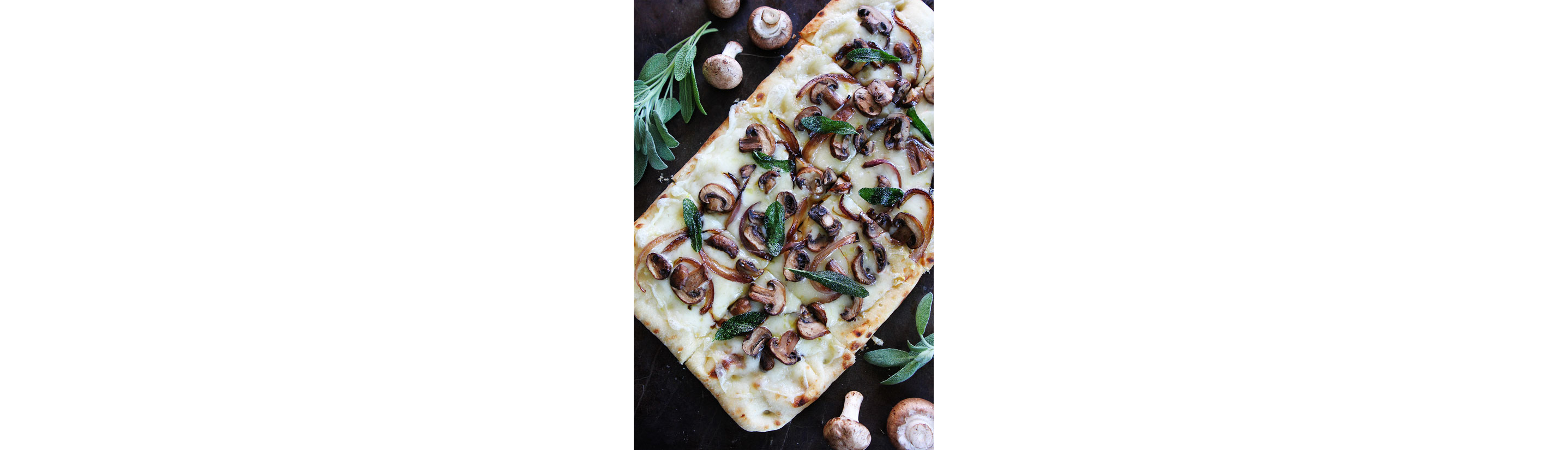 A flatbread dressed with sliced mushrooms and sage.