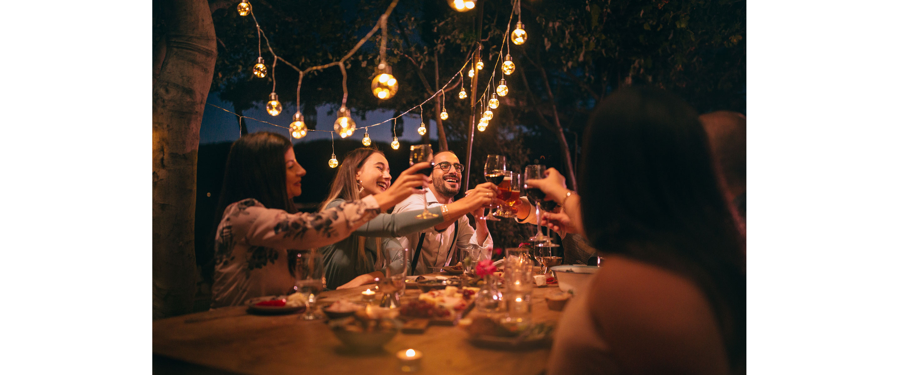 A group of people socializing at a dinner table.