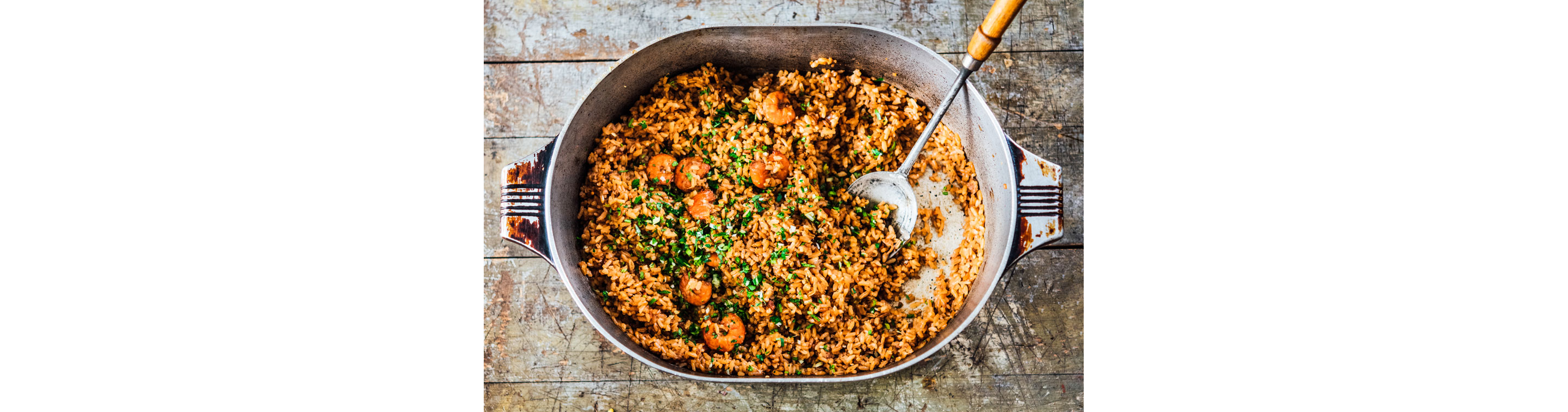 Shrimp jambalaya in a dutch oven with a serving spoon by chef Melissa M. Martin.