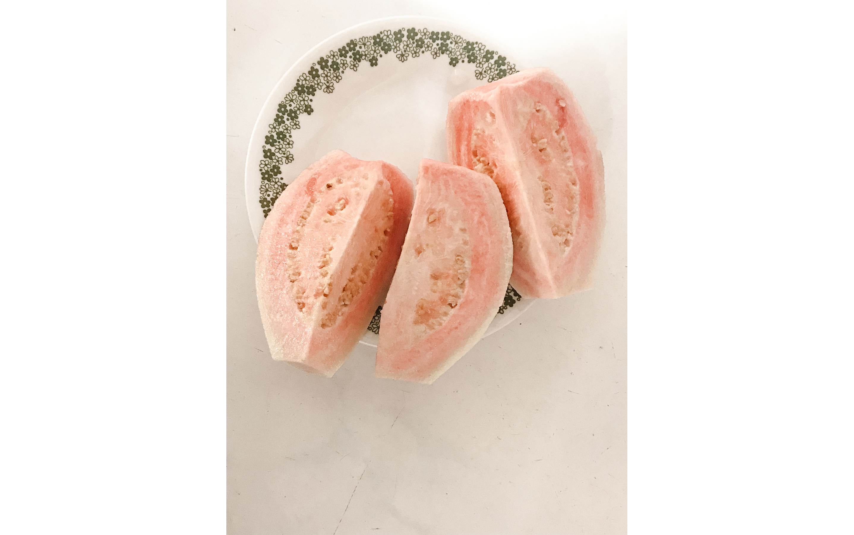 A small, delicate plate holding three slices of fruit.