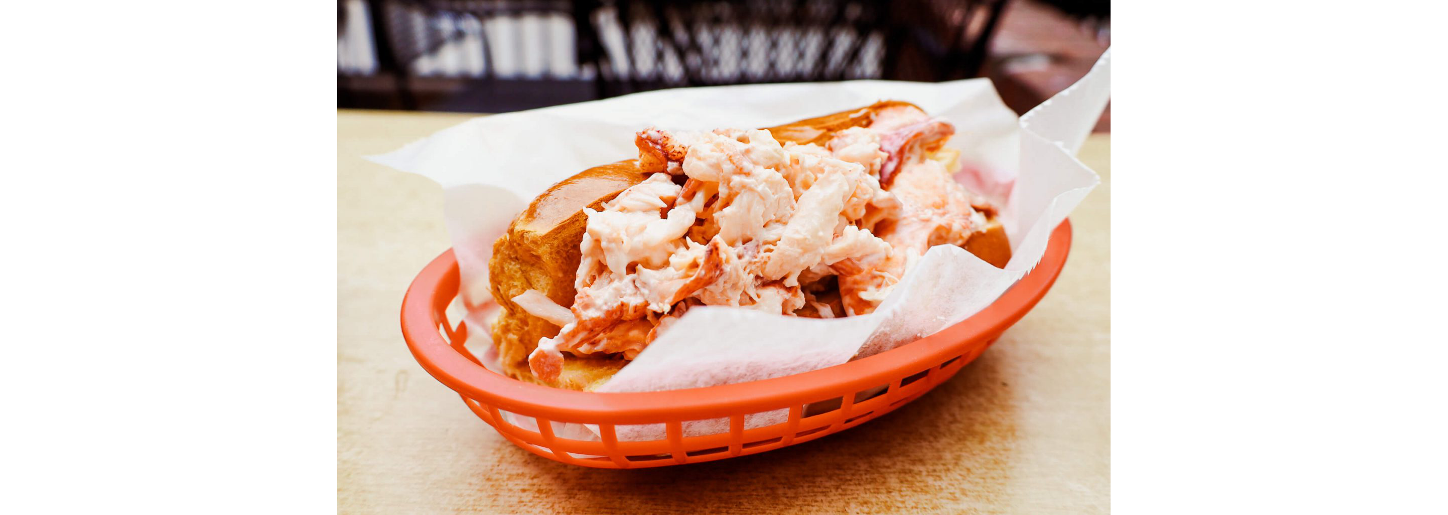 A lobster roll in a red basket.