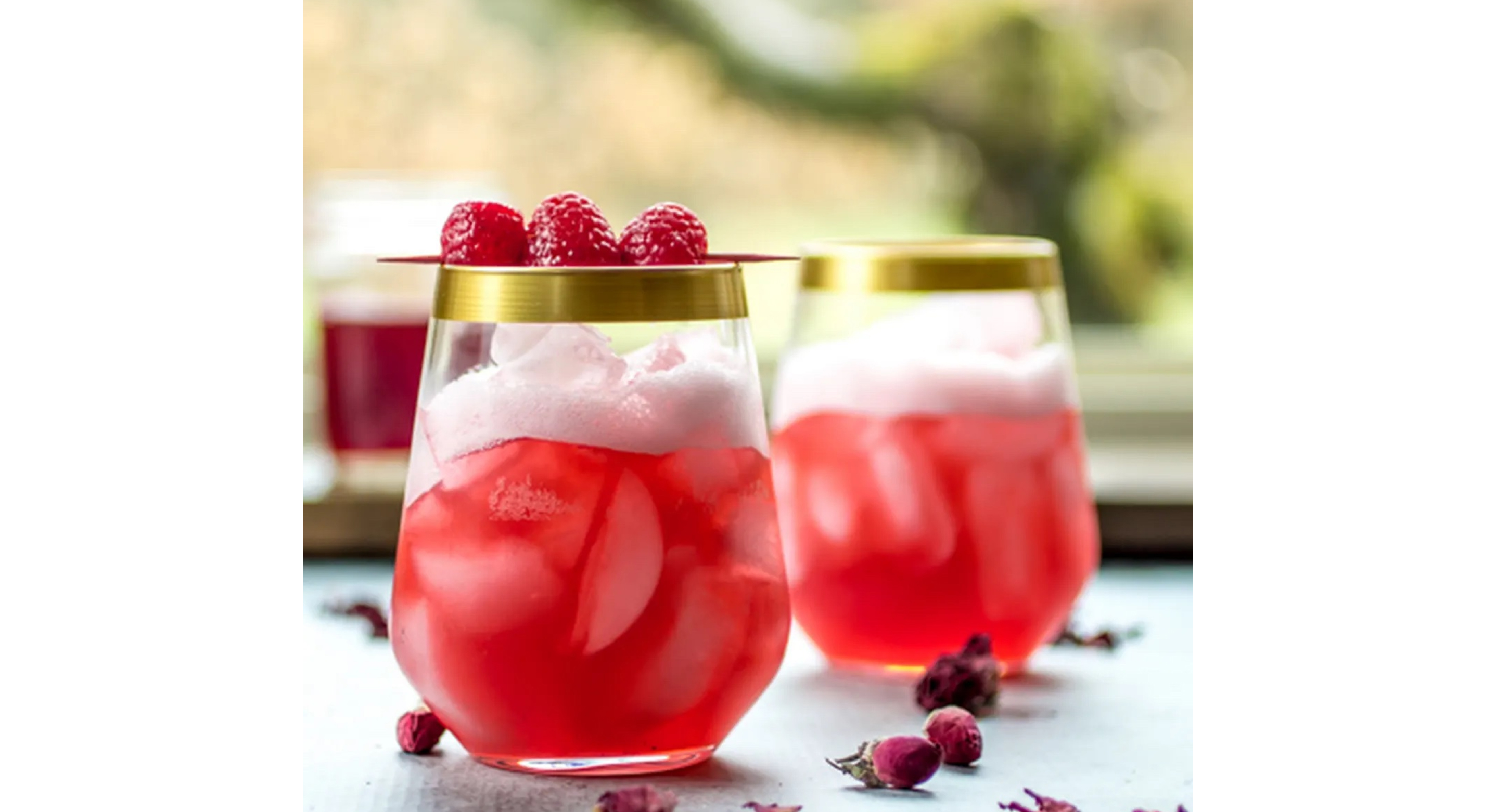 A pair of vibrant pink cocktails in stemless wine glasses.