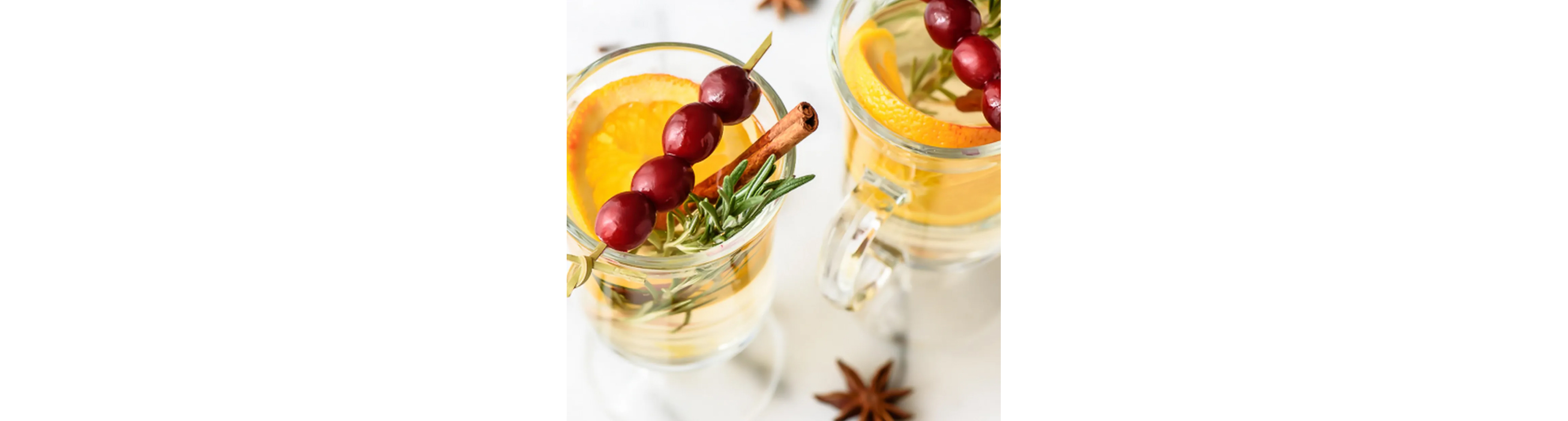 A well-garnished cocktail with cinnamon sticks, orange slices and more.