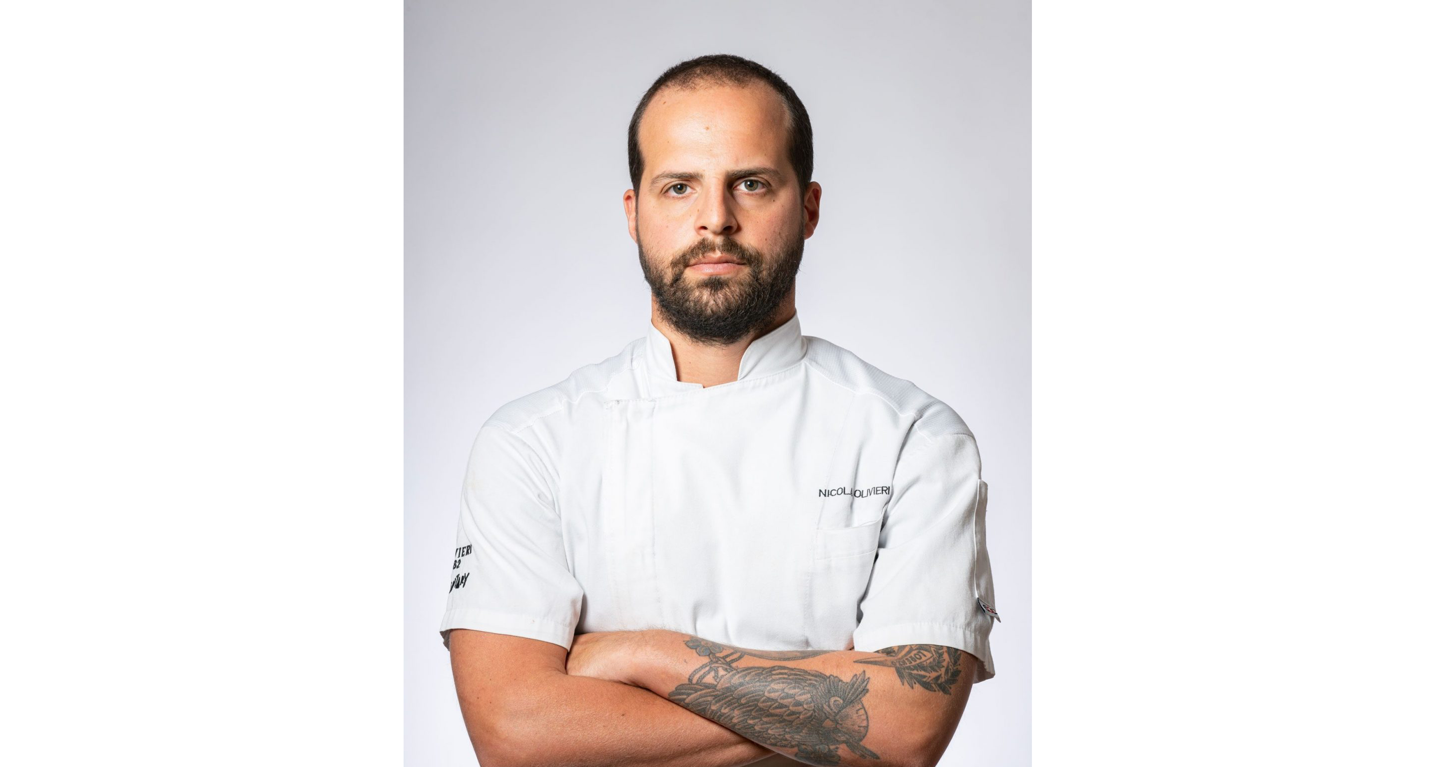 A professional portrait of Nicola Olivieri in his chef's uniform.