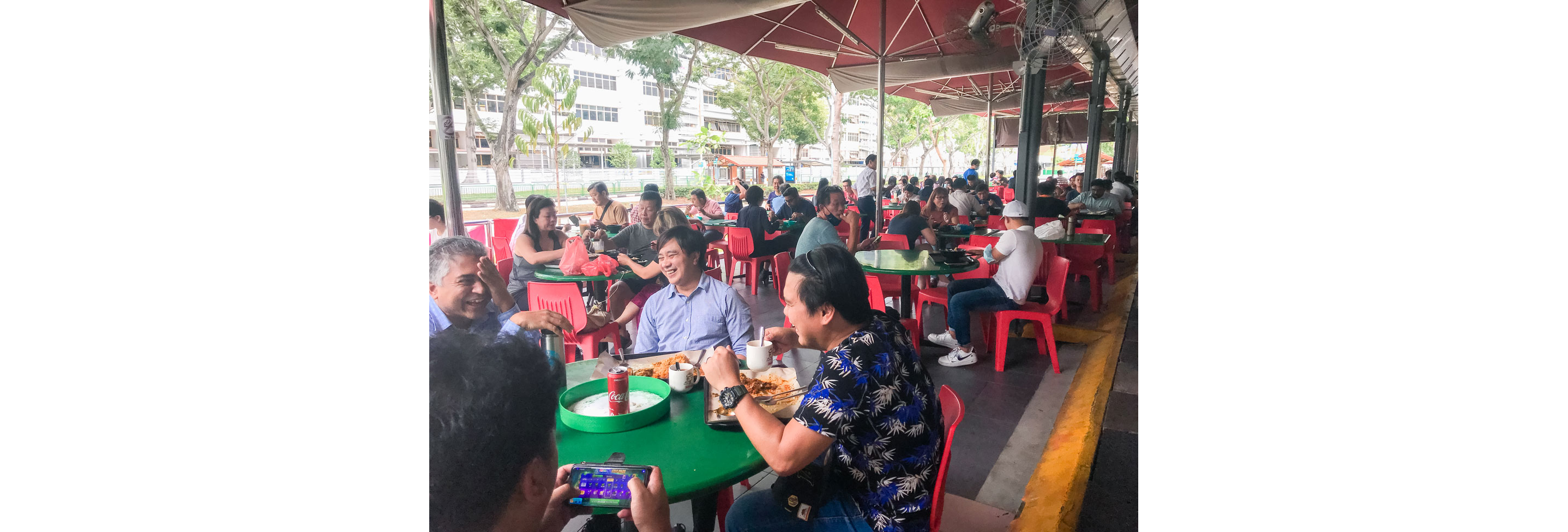 People sitting down enjoying their meals outside.