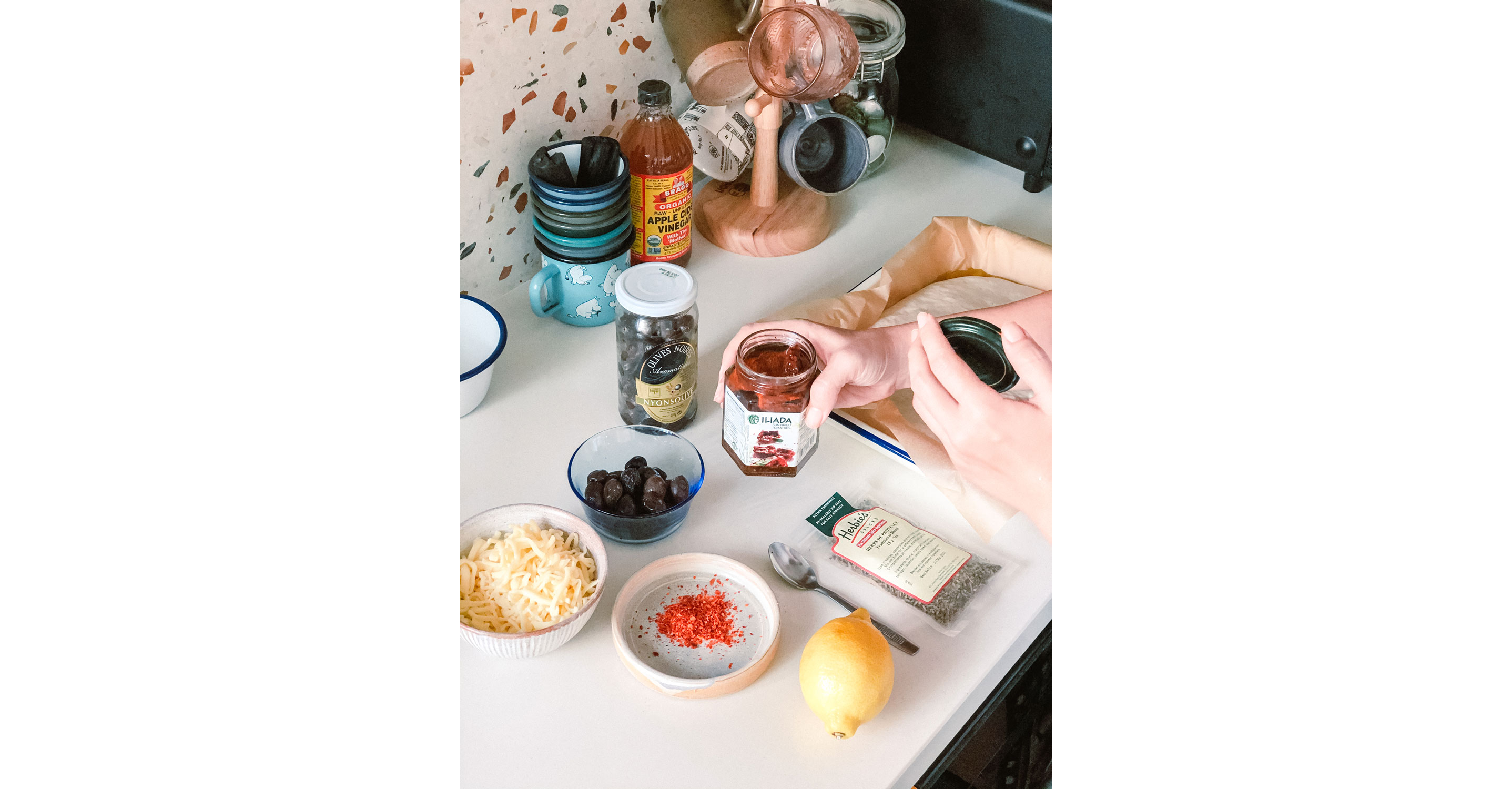 Medhā Lim holding a jar of sun-dried tomatoes.