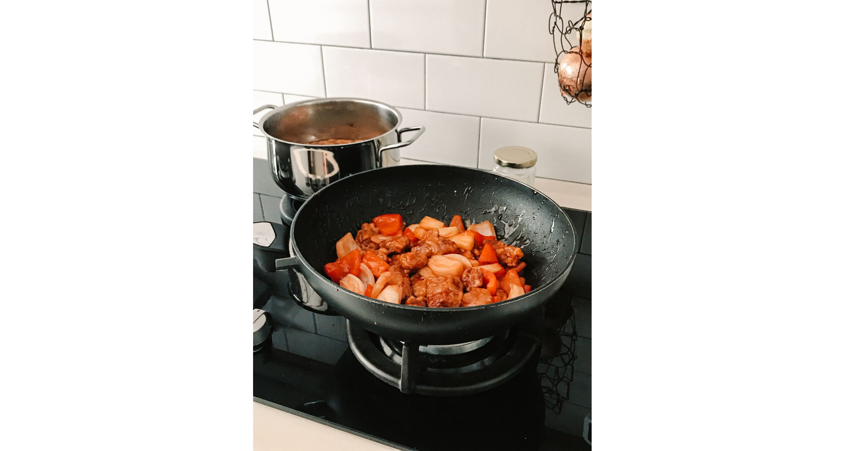 Sweet and sour pork sautéing in a pan.