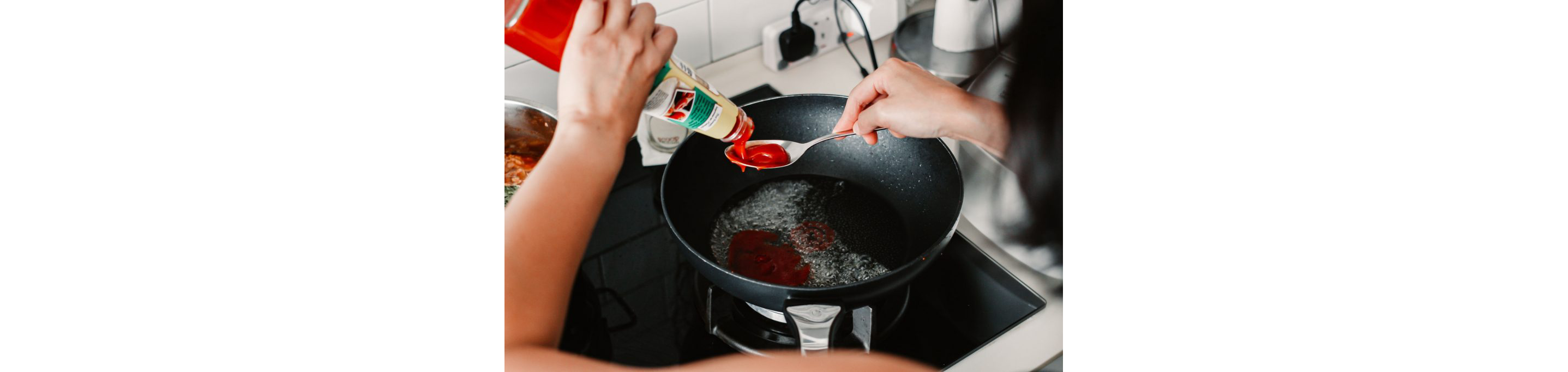 Melly Fong pouring ketchup into a spoon.