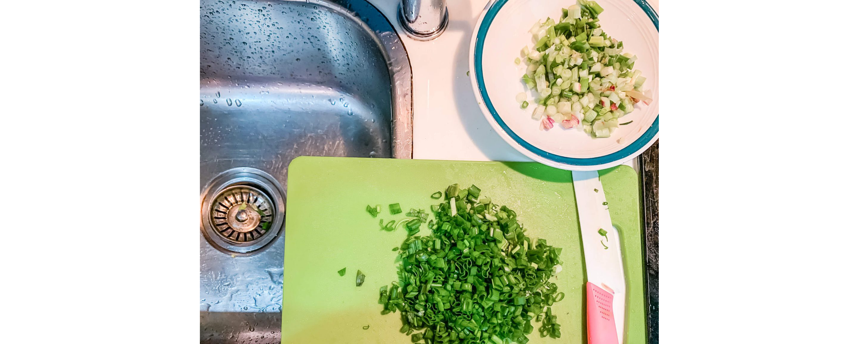 Chopped green onions on a cutting board and in a bowl.