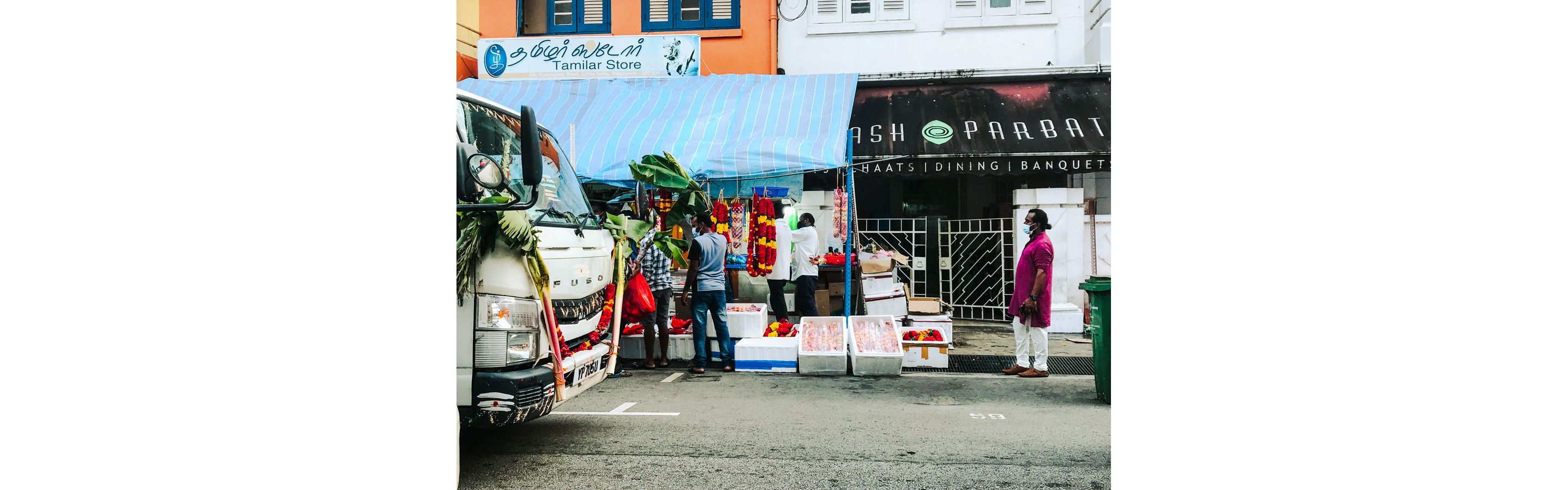 People ordering food at a small Indian food stall.