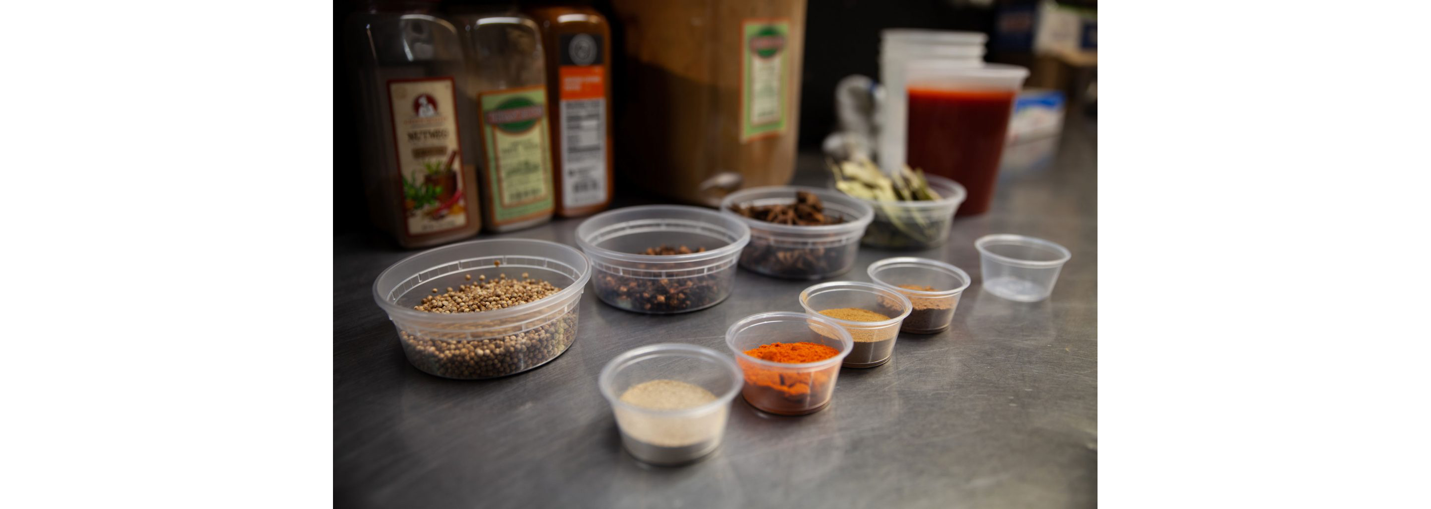Small containers filled with a variety of spices and seasonings for snapper soup.